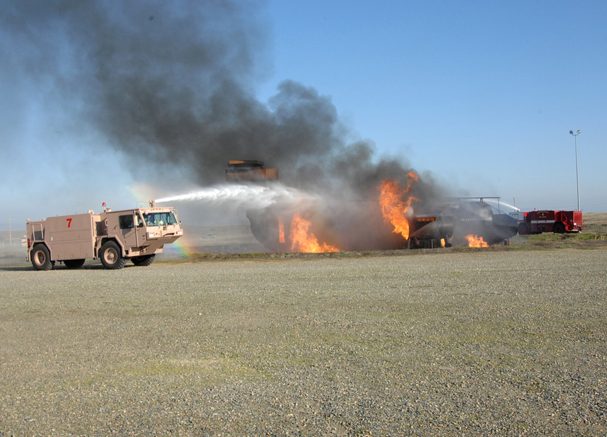 A 9th Civil Engineer Squadron fire department water truck sprays water at a live fire, inside a practice accident aircraft, during day 2 of the recent Phase II Operational Readines Exercise. (Photo by Sean Bhakta)