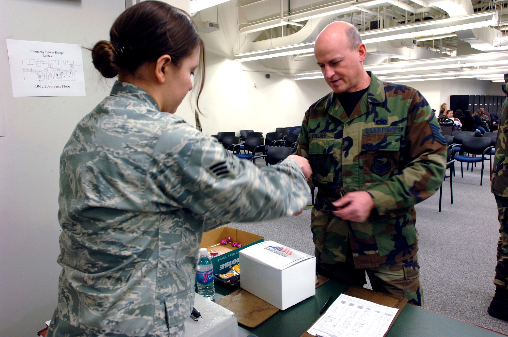 FAIRCHILD AIR FORCE BASE, Wash. – Master Sgt. James Voelker, 141st Maintenance Squadron, Aircraft NDI Technician, pays Senior Airman Sandra McCree, 92nd Force Support Squadron, Flight Kitchen, for his box meal during the Operational Readiness Exercise out processing at the 92nd Air Refueling Squadron and Logistics building, Jan 12. The ORE is preparing Fairchild Airmen for the upcoming Operational Readiness Inspection to be held in March. (U.S. Air Force photo / Airman 1st Class Melissa L. Barnett)