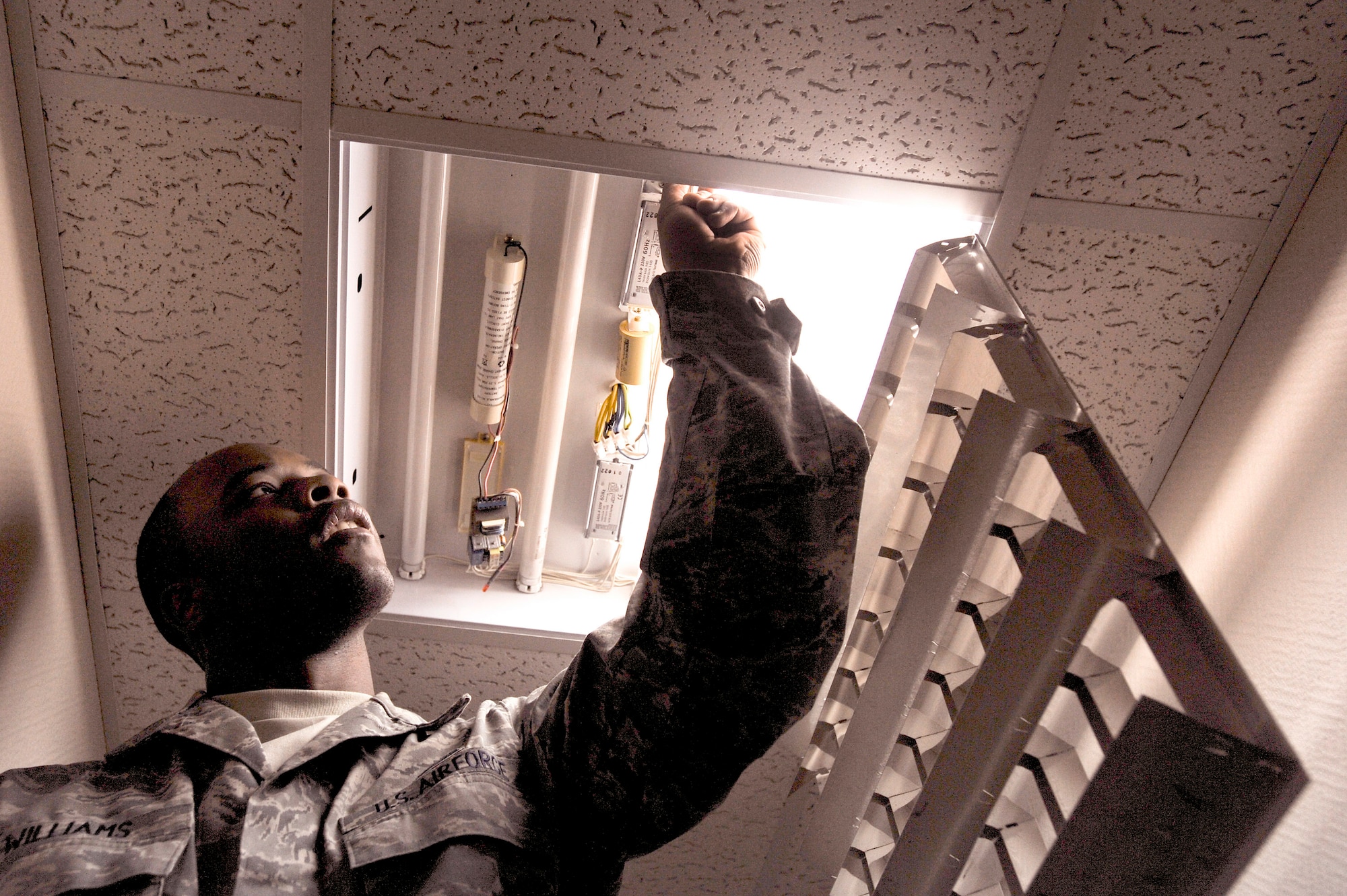 Senior Airman Augustus Williams checks the starters in a light fixture Jan. 14 at an air base in Southwest Asia. Airman Williams is a 379th Expeditionary Civil Engineer Squadron electrician and deployed from Pope Air Force Base, N.C. He is a native of Augusta, Ga.(U.S. Air Force photo/Staff Sgt. Joshua Garcia)