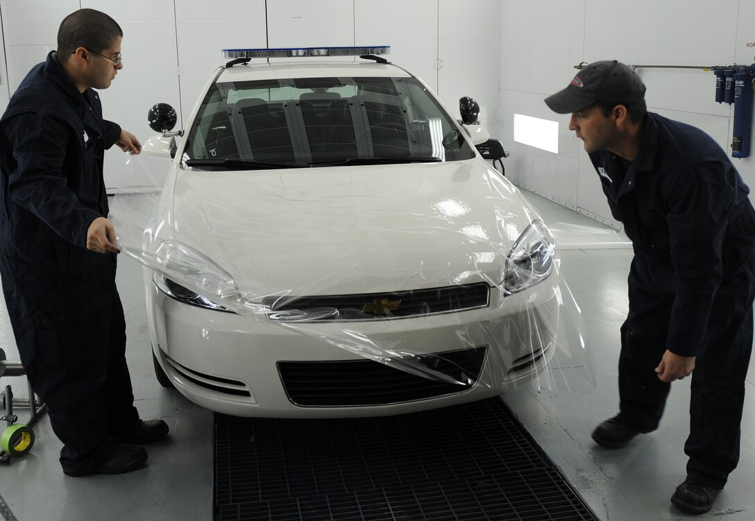 LANGLEY AIR FORCE BASE, Va. -- Senior Airman Jaime Cruz, 1st Logistics Readiness Squadron vehicle mechanic and Mr. Bill Johnston, 1st LRS ally trades technician, put a protective piece of clear coating over the hood of a car Jan. 16.  This coating is used to protect the car's paint from chipping or breaking easily.  The 1st LRS recently won the 2008 Air Combat Command Maj. Gen. Warren R. Carter Logistics Effectiveness Award, also known as the Daedalian Award. (U.S. Air Force photo/Airman 1st Class Zachary Wolf)
