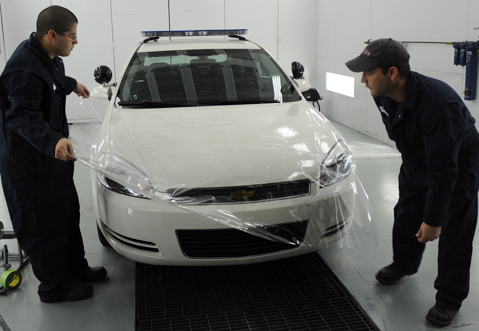 LANGLEY AIR FORCE BASE, Va. -- Senior Airman Jaime Cruz, 1st Logistics Readiness Squadron vehicle mechanic and Mr. Bill Johnston, 1st LRS ally trades technician, put a protective piece of clear coating over the hood of a car Jan. 16.  This coating is used to protect the car's paint from chipping or breaking easily.  The 1st LRS recently won the 2008 Air Combat Command Maj. Gen. Warren R. Carter Logistics Effectiveness Award, also known as the Daedalian Award. (U.S. Air Force photo/Airman 1st Class Zachary Wolf)
