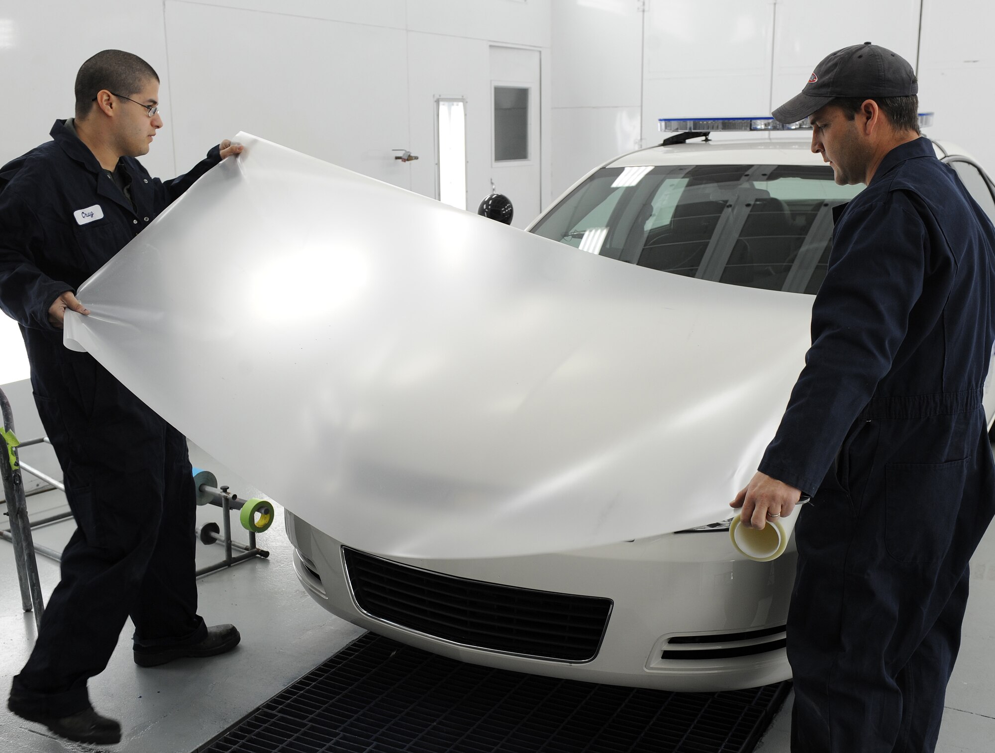 LANGLEY AIR FORCE BASE, Va. -- Senior Airman Jaime Cruz, 1st Logistics Readiness Squadron vehicle mechanic and Mr. Bill Johnston, 1st LRS ally trades technician, put a protective piece of clear coating over the hood of a car Jan. 16.  This coating is used to protect the car's paint from chipping or breaking easily.  The 1st LRS recently won the 2008 Air Combat Command Maj. Gen. Warren R. Carter Logistics Effectiveness Award, also known as the Daedalian Award.  (U.S. Air force photo/Airman 1st Class Zachary Wolf)
