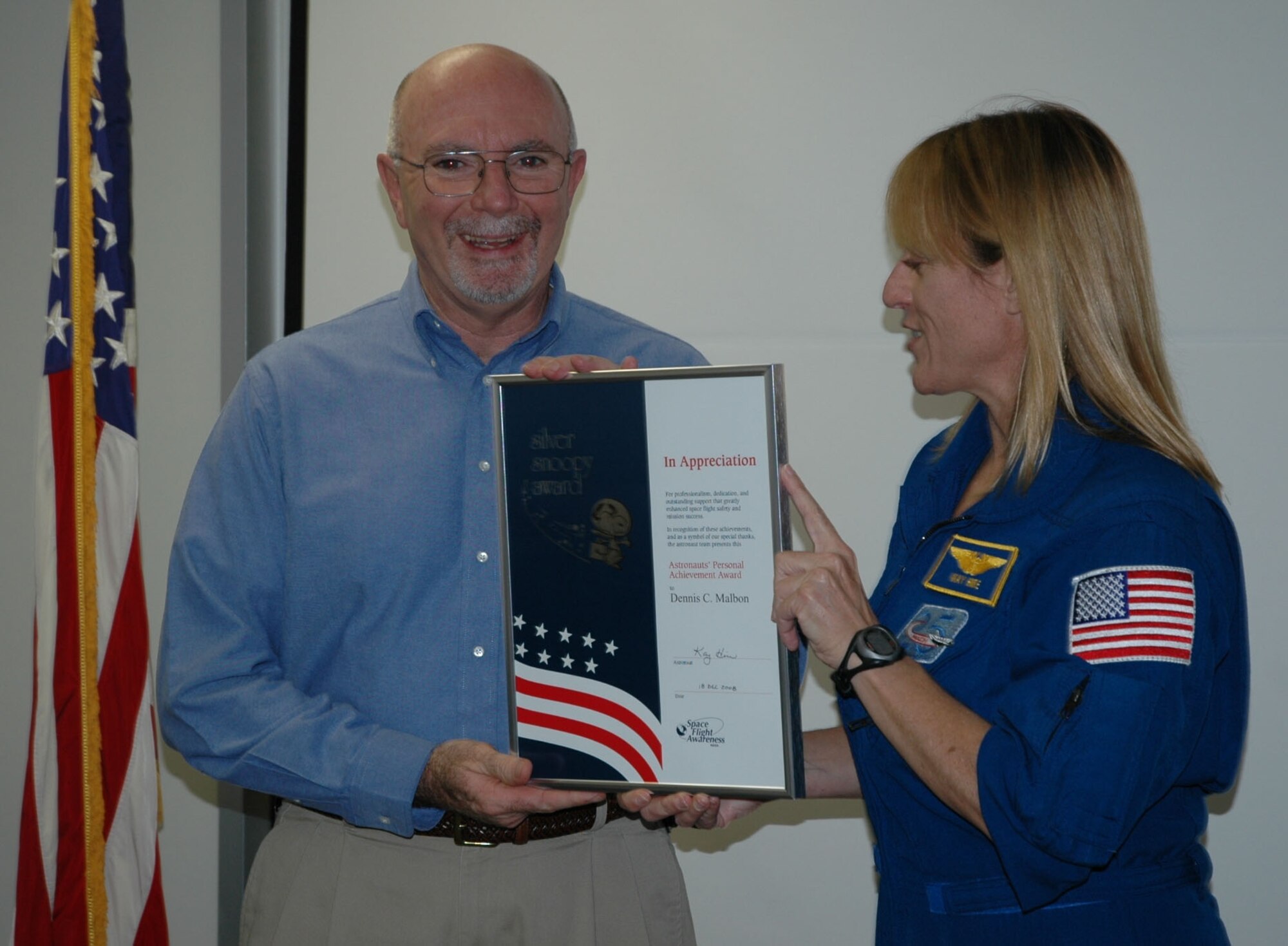 Chris Malbon accepts his Silver Snoopy award for a lifetime of service to the space program from Astronaut Kay Hire Dec. 19.