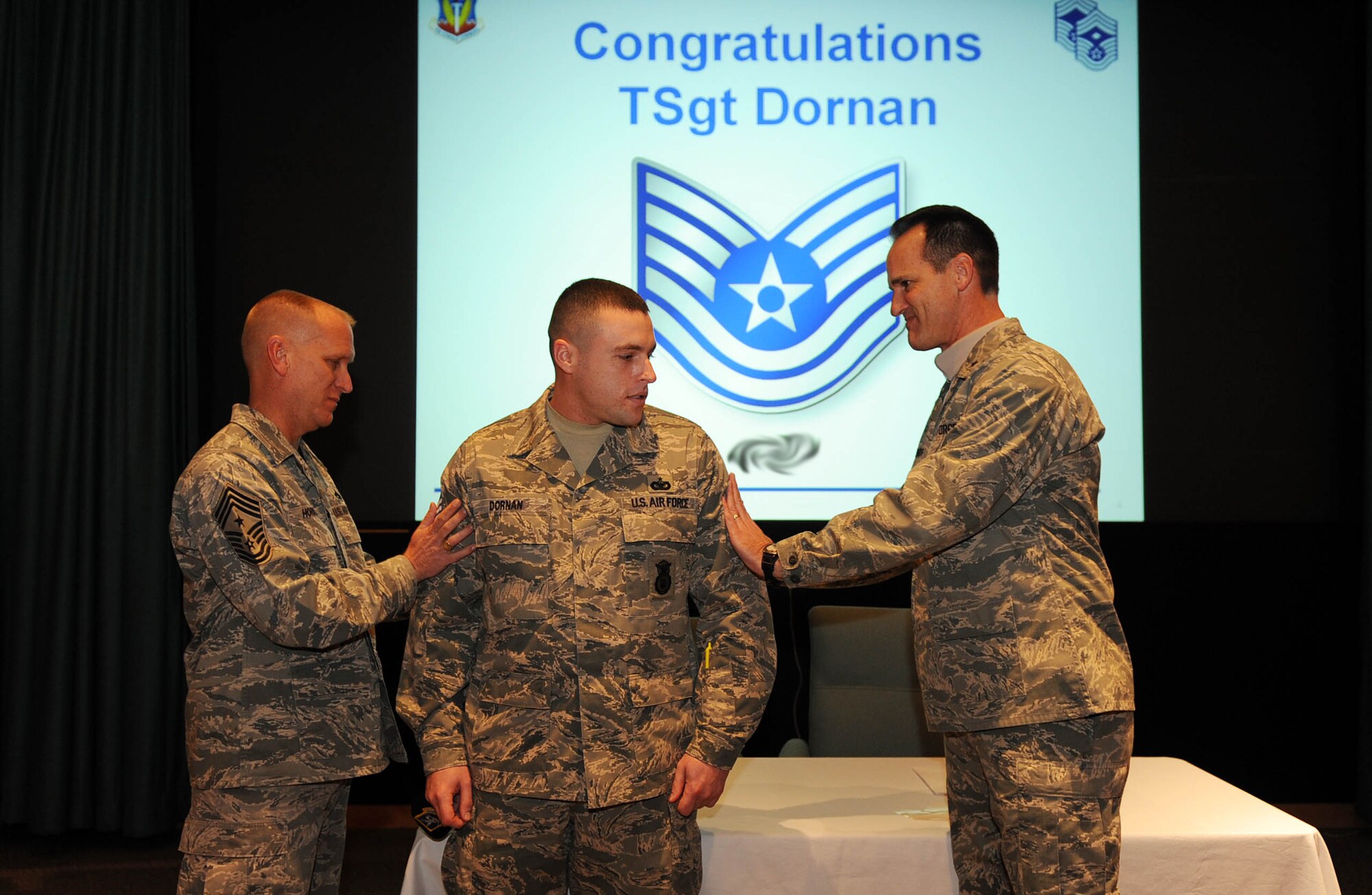 OFFUTT AIR FORCE BASE, Ne. – Brig. Gen. James Jones, 55th Wing commander, and Chief Master Sgt. Brian Hornback, 509th Bomb Wing command chief, promote Staff Sgt. Ryan Dornan, 509th Security Forces Squadron to technical sergeant during an Air Combat Command Chief Master Sergeant conference Jan. 15. Sergeant Dornan was attending the conference as part of an Airmen’s panel. The conference consisted or more than 140 new ACC command chiefs. (U.S. Air Force photo/Josh Plueger)