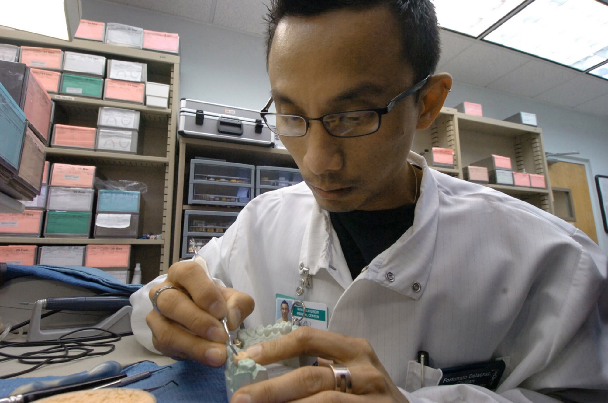 Fornato Dela Cruz, 779th Dental Squadron dental laboratory technician, uses a dental instrument to build a tooth mold for a ceramic dental crown. (U.S. Air Force photo by Bobby Jones)

