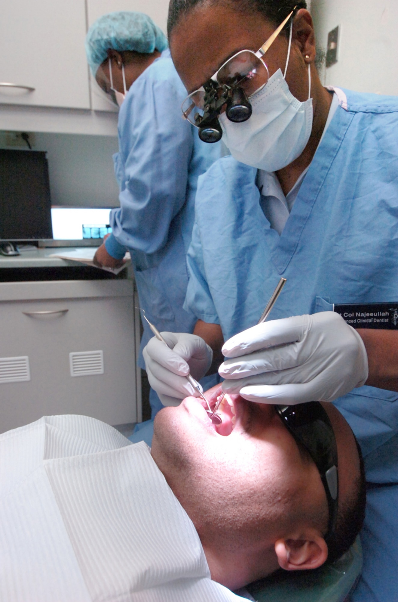 Lieutenant Col. Baseemah Najeeullah, 779th Dental Squadron dentist, performs a dental examination on a patient Jan.12. (U.S. Air Force photo by Bobby Jones)
