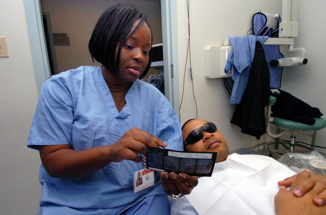 Staff Sgt. LaToya Williams, 779th Dental Squadron dental technician, shows Tech. Sgt. Naeem Stanley, 316th Logisitics Readiness Squadron vehicle operator, a radiographic X-Ray of his molars prior to a routine dental examination Jan. 12. (U.S. Air Force photo by Bobby Jones)
