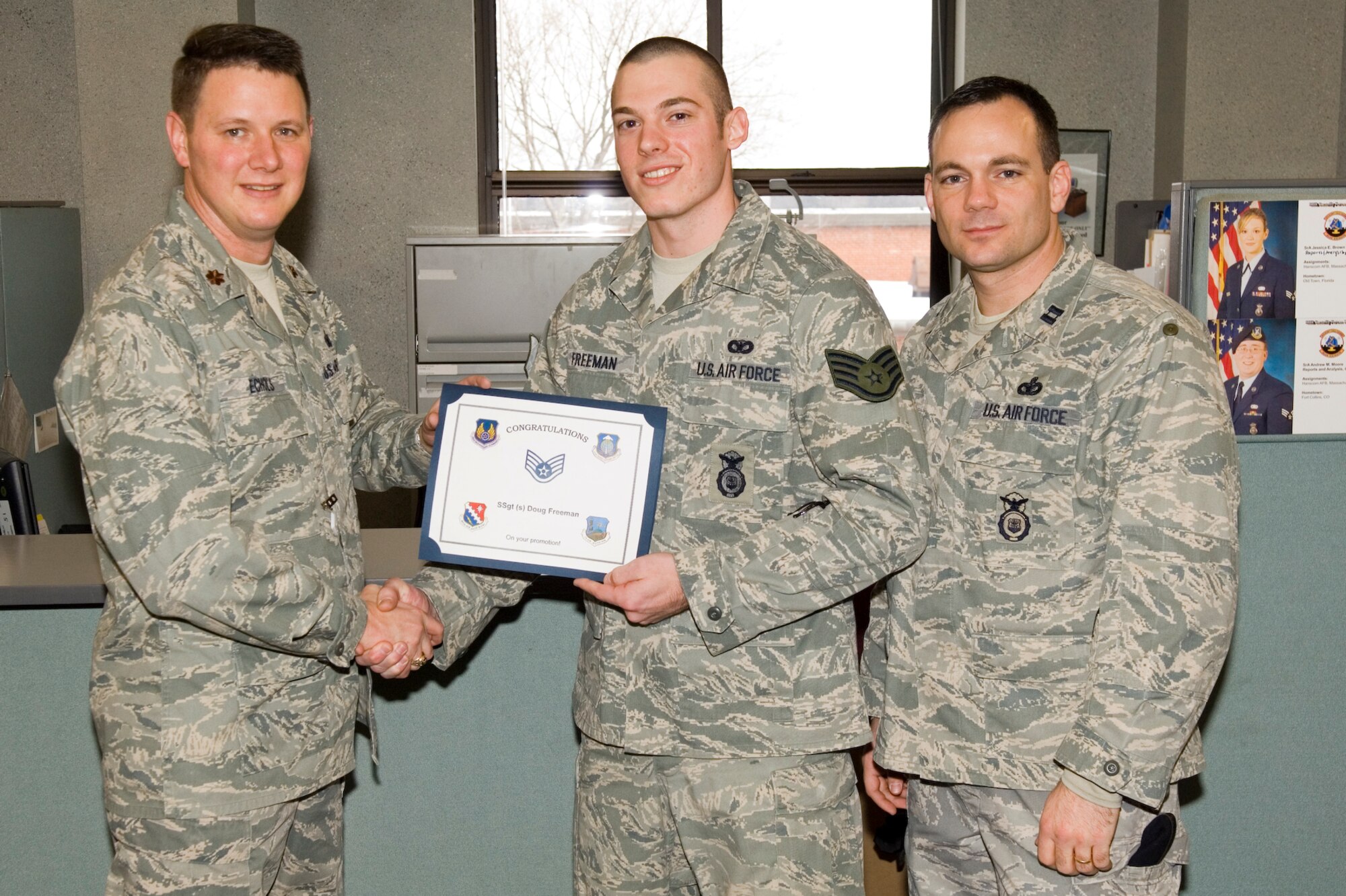 HANSCOM AIR FORCE BASE, Mass. - Senior Airman Douglas Freeman of the 66th Security Forces Squadron, who was selected for promotion to staff sergeant Jan. 15, is congratulated by Major Chris Echols (left), 66 SFS commander and Capt. Chris Robinson (right), 66 SFS, operations officer. (U.S. Air Force Photo by Rick Berry)