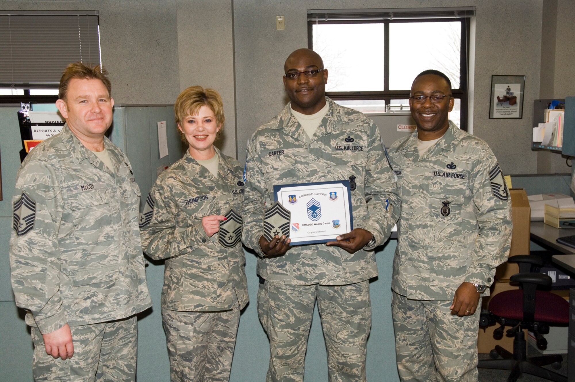 HANSCOM AIR FORCE BASE, Mass. - Senior Master Sgt. Woodrow ‘Woody’ Carter of the 66th Security Forces Squadron, who was selected for promotion to chief master sergeant Jan. 15, stands with current chiefs (from left) Chief Master Sgt. Mike McCoy, 66th Mission Support Group, Chief Master Sgt. Ginger Thompson, 66th Medical Group, and Chief Master Sgt. Al Thompson, 66 SFS. (U.S. Air Force Photo by Rick Berry)