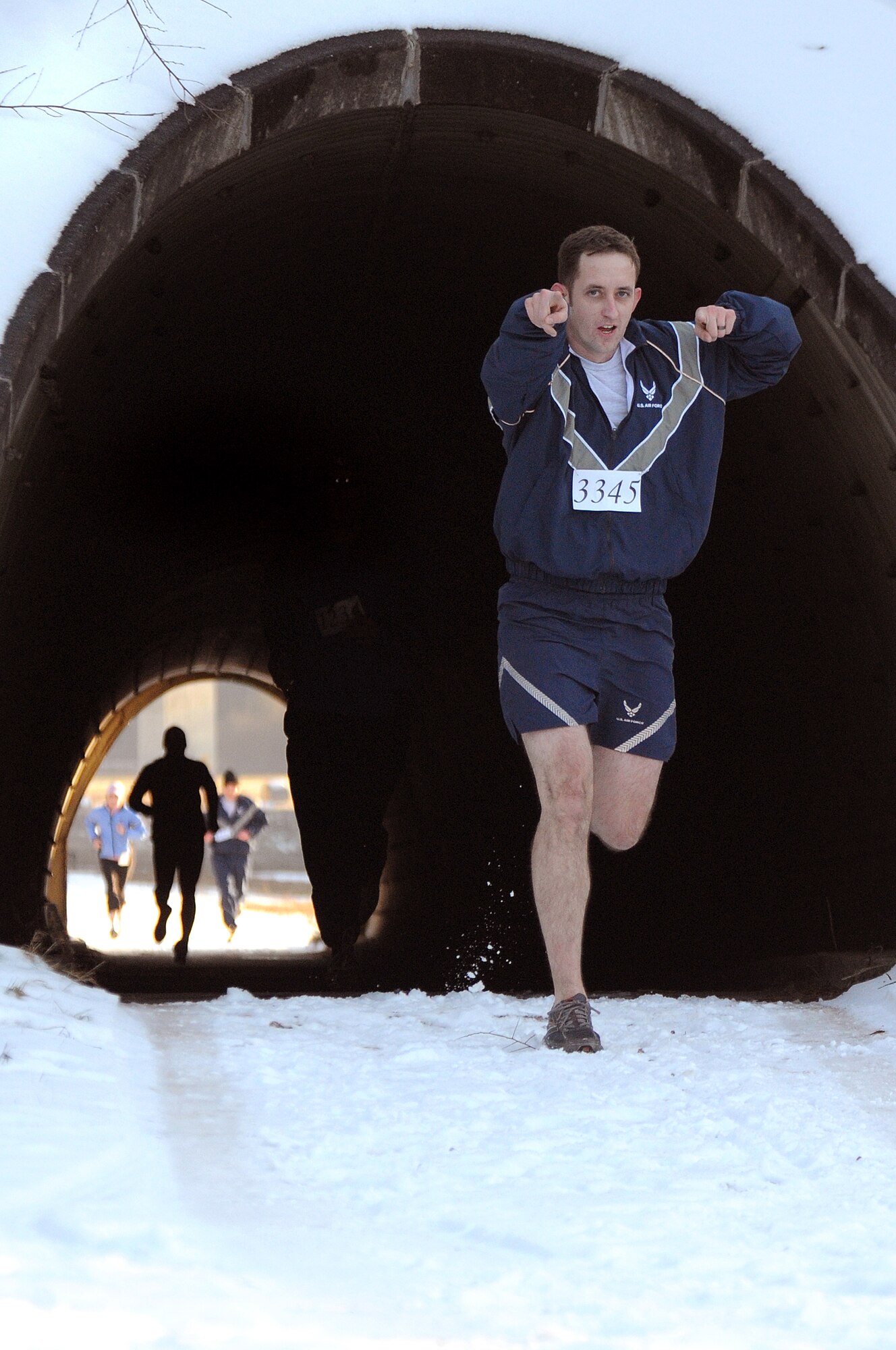 Staff Sgt. Justin Betts, 1st Combat Communications Squadron, and other participants finish the last leg of the Penguin Prediction Run Jan. 15, 2009, on the 86th Construction and Training Squadron compound at Ramstein Air Base.  The run, which is to be an annual event, was held to promote fitness and increase awareness of the challenges facing abandoned women and children in Pristina, Kosovo. (U.S. Air Force photo by Senior Airman Nathan Lipscomb)