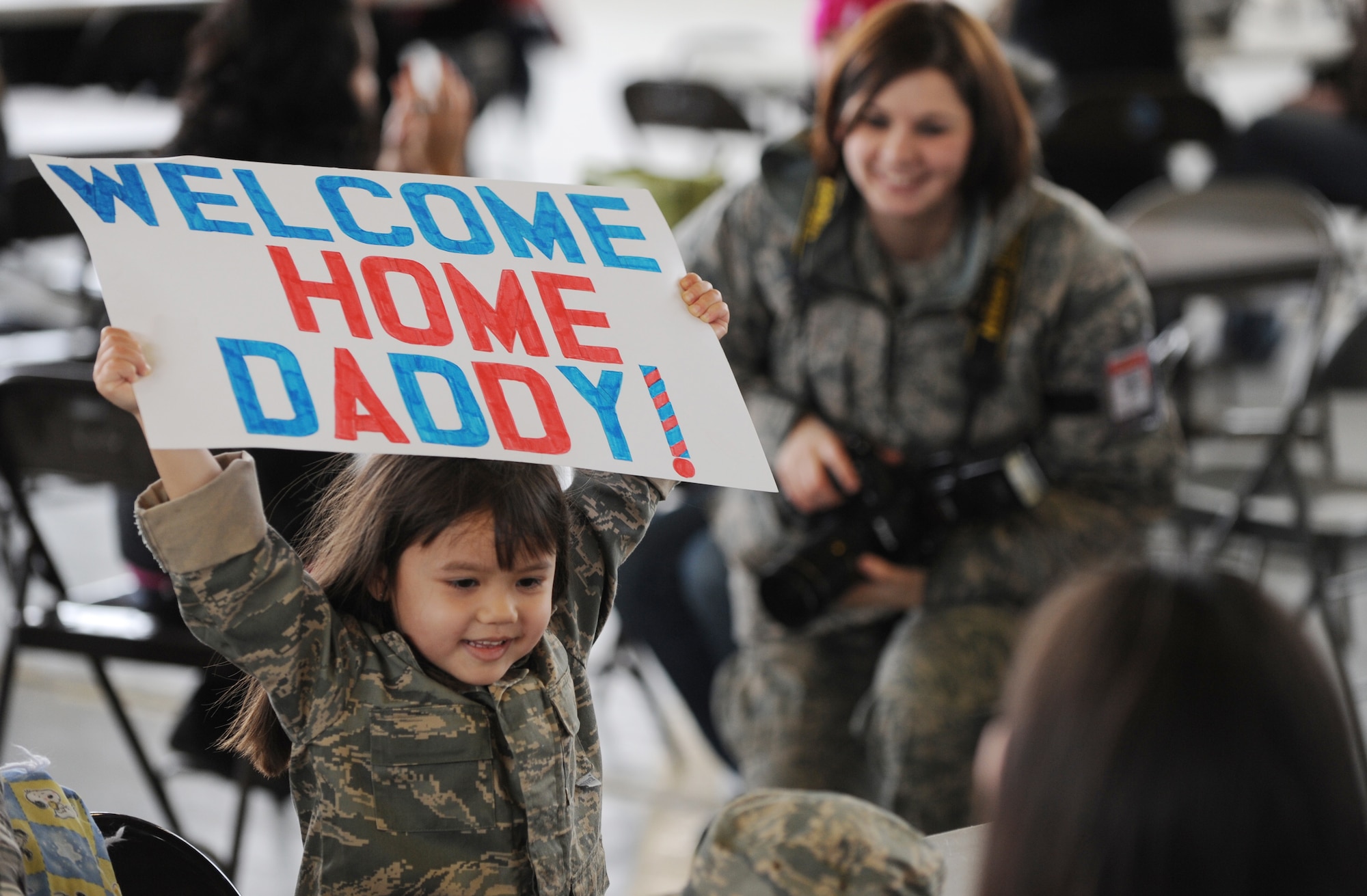 MOUNTAIN HOME AIR FORCE BASE, Idaho -- The daughter of one of the Gunfighters returning from Afghanistan displays a homemade sign for her dad to see Jan. 15. Nearly 20 F-15E Strike Eagles and approximately 400 Gunfighters were deployed to Afghanistan in support of Operation Enduring Freedom. (U.S. Air Force photo/ Senior Airman Ryan Crane)