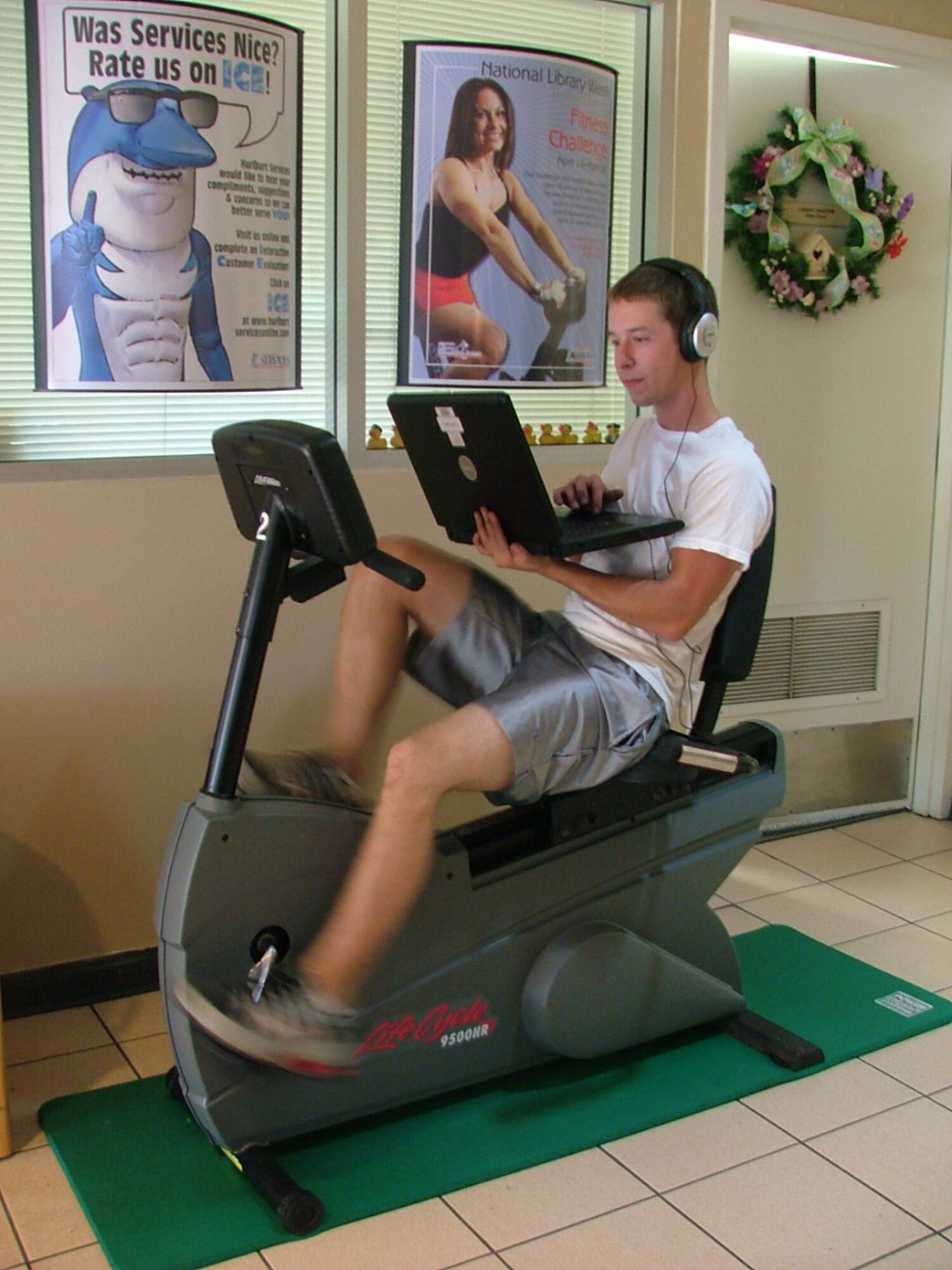 Airman 1st Class Jason Linney surfs the Internet on a library laptop during the fitness cycle marathon. (Courtesy photo)