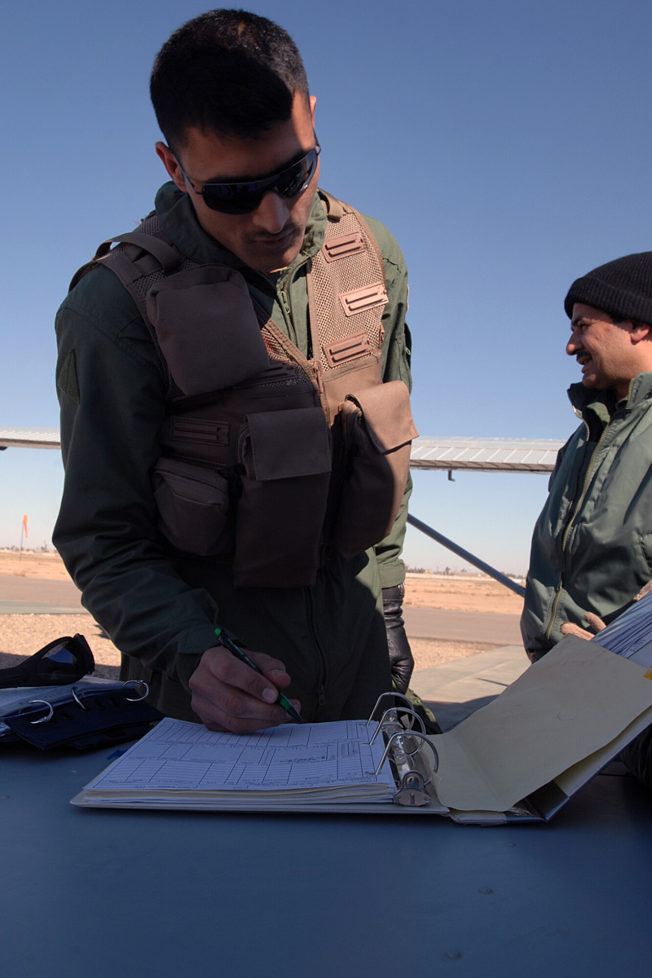 KIRKUK REGIONAL AIR BASE, Iraq – Iraqi Air Force student pilot, Lt. Hassan, logs his flight hours upon return from a training sortie Jan. 14. This sortie marked the 5K-hour flying milestone for the since the launch of the training wing. (U.S. Air Force photo by Senior Airman Eunique Stevens)