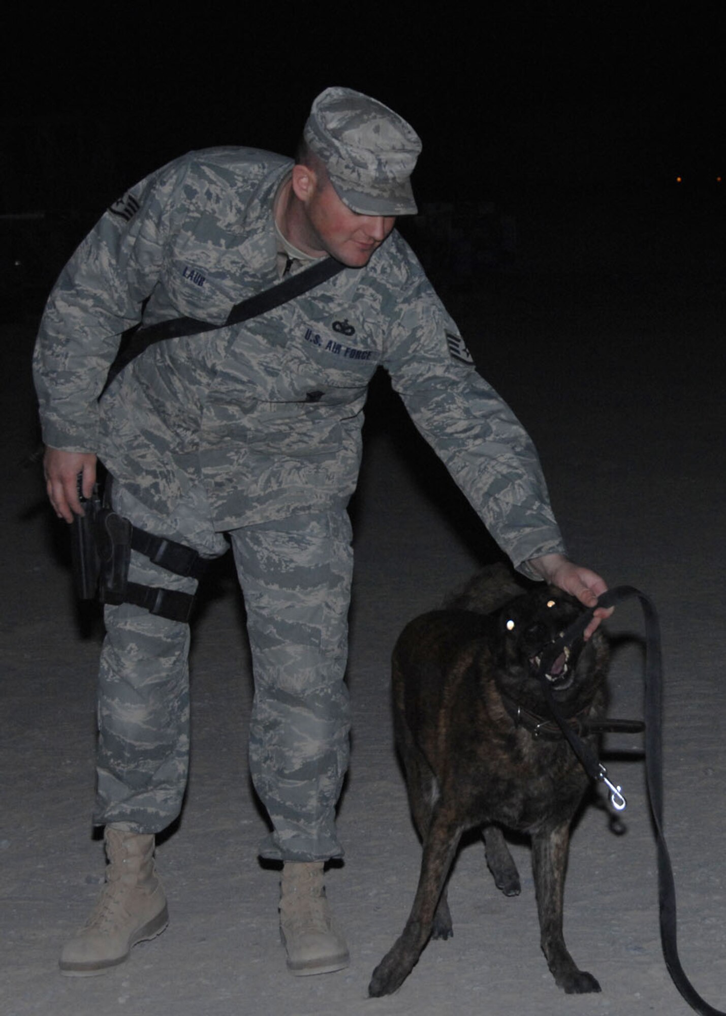 SOUTHWEST ASIA -- Staff Sgt. Garry Laub, 823rd Security Forces Squadron, plays with Kelly, Air Force military working dog, before his flight into Iraq at an air base in Southwest Asia, Jan. 13. Sergeant Laub played with Kelly to calm her down before they boarded the aircaft. (U.S. Air Force photo/Senior Airman Courtney Richardson)