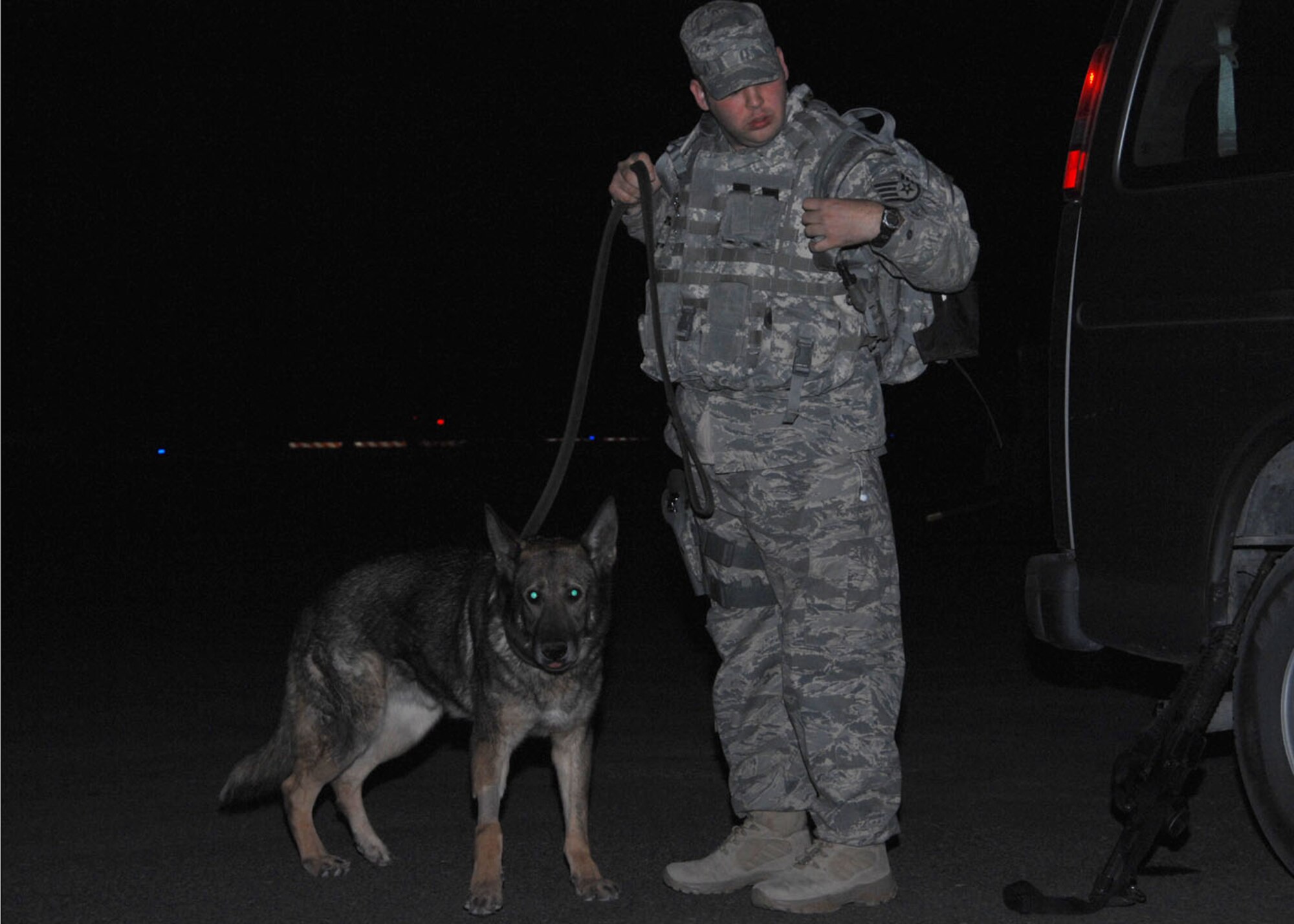 SOUTHWEST ASIA -- Staff Sergeant Joshua Germann, 822nd Security Forces Squadron, gears up with Edo, Air Force military working dog, for his flight into Iraq at an air base in Southwest Asia, Jan. 13. Edo had a full medical checkup before his departure with his handler. (U.S. Air Force photo/Senior Airman Courtney Richardson)