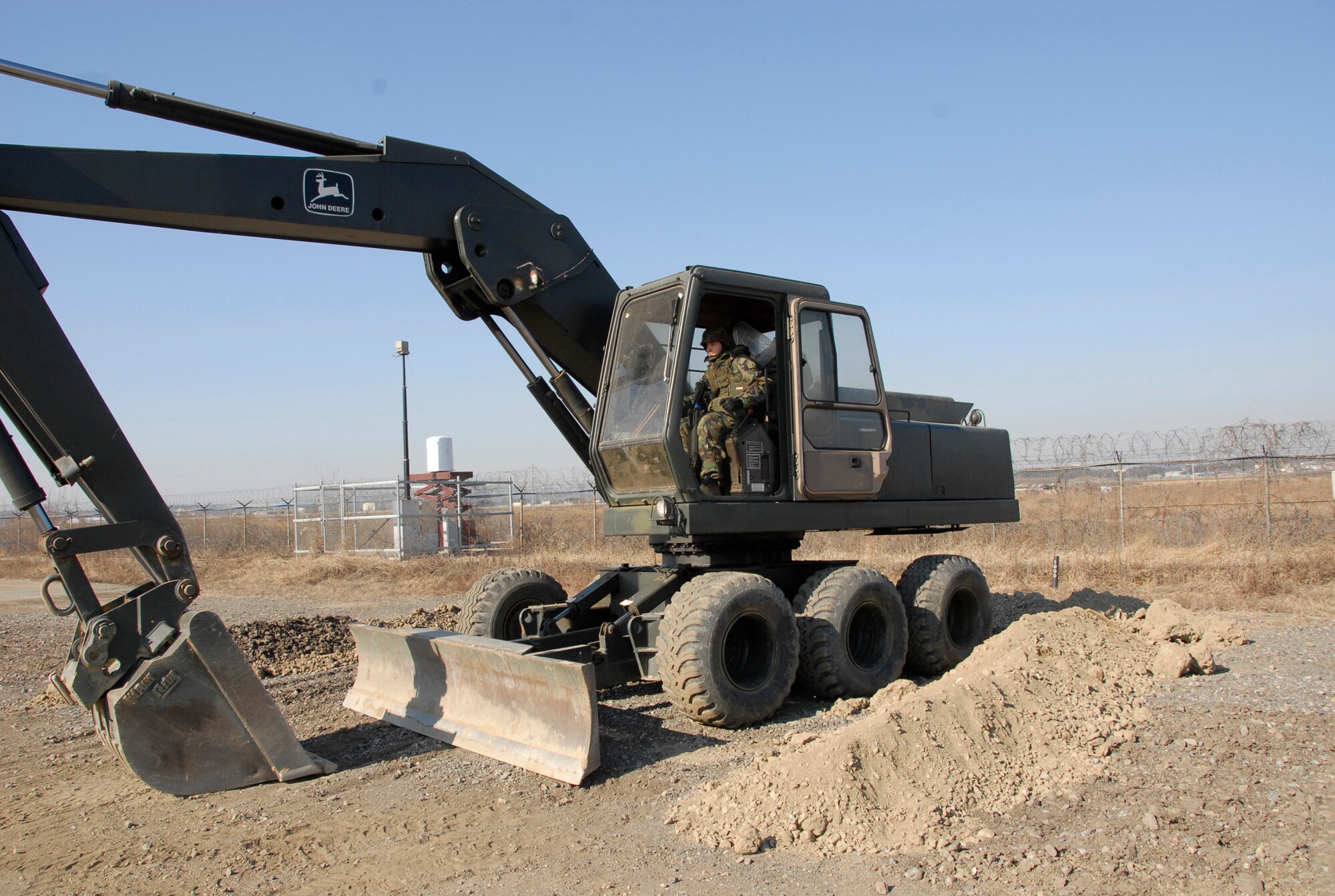 Airman 1st Class Tyler Heath operates an excavator to remove debris from the airfield after a simulated attack during Exercise Beverly Bulldog 09-01 on Osan Air Base Jan. 15.  The 51st Fighter Wing is currently undergoing a week-long Operational Readiness Exercise to test its ability to conduct war time missions. Airman Heath is assigned to the 51st Civil Engineer Squadron. (US Air Force photo by Staff Sgt. Scottie T. McCord)