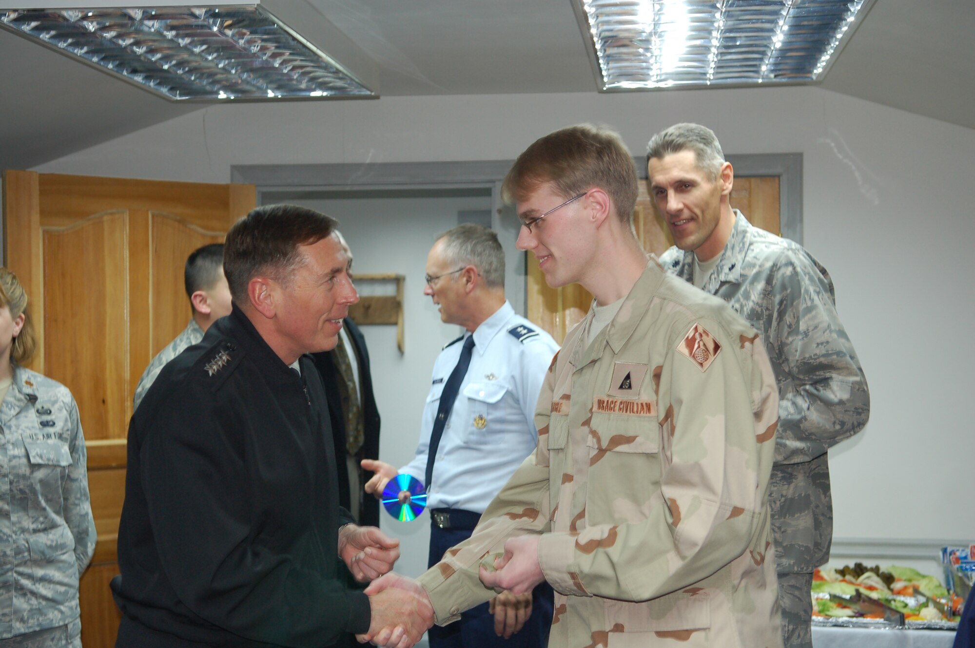 General David Petraeus, U.S. Central Command commander, provides his personal "coin" to Mr. Ryan Eargle, Manas Air Base Realty Service Field Office Representative, following a mission brief from wing leadership. The general made his first visit to the 376th AEW since becoming the CENTCOM commander in October 2008. His stop at Manas kicked off a several day visit to the Central Asian country. Manas AB serves as the premiere air mobility and air refueling hub for operations in Afghanistan. (U.S. Air Force photo/Maj. Damien Pickart)