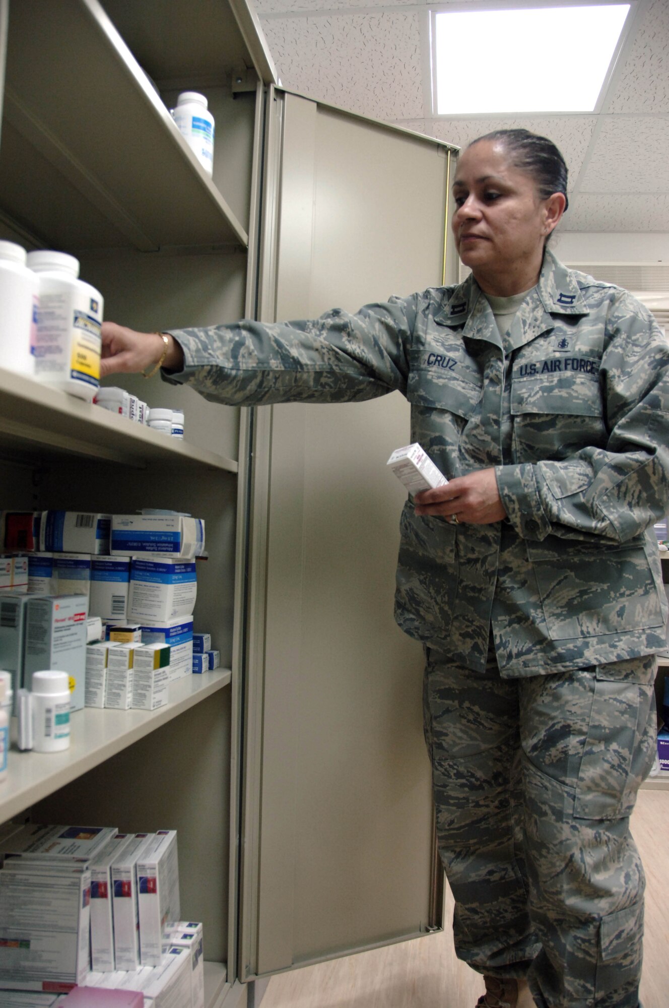 SOUTHWEST ASIA -- Capt. Lourdes Cruz, an Air Force nurse and officer in charge of the 380th Expeditionary Medical Group medical clinic, inventories medications here. The clinic has a full pharmacy and has the capability to diagnose and treat most common injuries and illnesses. (U.S. Air Force photo by Staff Sgt. Mike Andriacco) (Released)