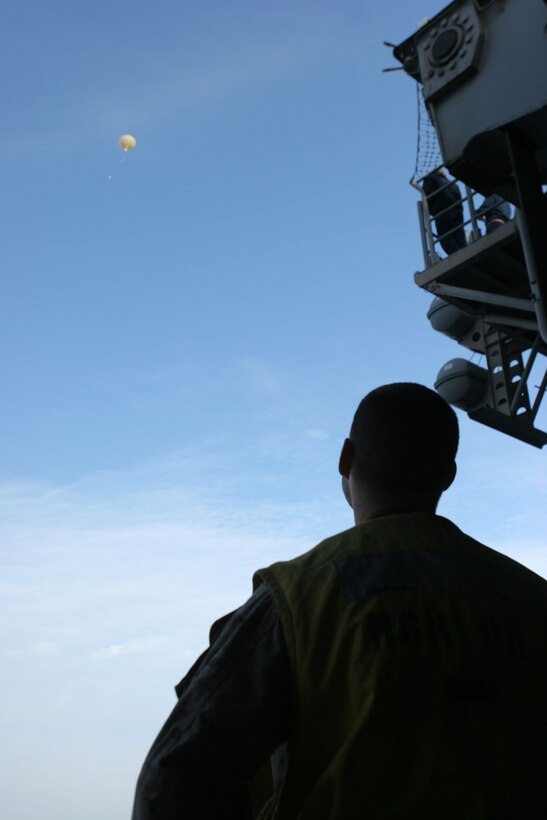 Capt. Jonathan Pfuntner, assistant communications officer with the 26th Marine Expeditionary Unit, watches as the SkySat High Altitude Operational Payload system's balloon and payload quickly rises to its operational altitude. This was the first launch of SkySat from the USS Iwo Jima and only the second Naval vessel from which the unit has been launched. SkySat could one day help Marines in the field with handheld radios communicate as far as 500 miles, regardless of terrain. 26th MEU Marines learned about the system Jan. 12 and got hands-on with the gear during the next several days.