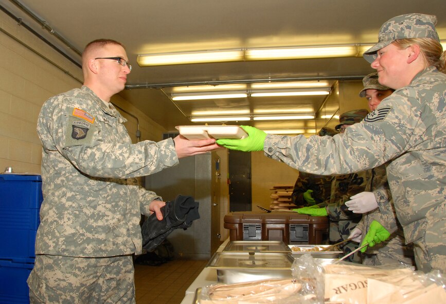 Technical Sergeant (TSgt) Trisha Theisen of the 185th Air Refuel Wing, Sioux City, Iowa, serves hot chow to members of the 1st Battalion, 168th Infantry Regiment on 17 January, 2009.  TSgt Theisen is supporting Iowa Army National Guard troops in Washington DC.  Iowa Guard troops are in Washington DC to support local law enforcement during the inauguration of President Barack Obama.   (US Air Force Photo by TSgt Brian Cox)(Released by MSgt Vincent DeGroot, Public Affairs Manager)