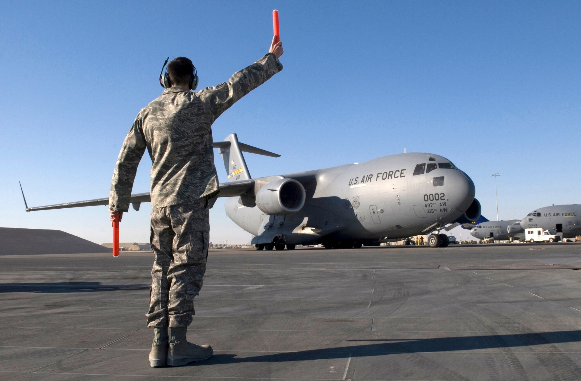 Senior Airman Kenneth Fowler, an 8th Expeditionary Air Mobility Squadron C-17 Crew Chief, marshals a C-17 Globemaster III out of its parking spot, Jan. 16, 2009, at an undisclosed location in Southwest Asia.  Senior Airman Fowler hails from Danville, Va. and is deployed from Charleston Air Force Base, S.C. in support of Operation Iraqi and Enduring Freedom and Joint Task Force- Horn of Africa.  (U.S. Air Force Photo by Airman 1st Class Andrew Satran/Released)