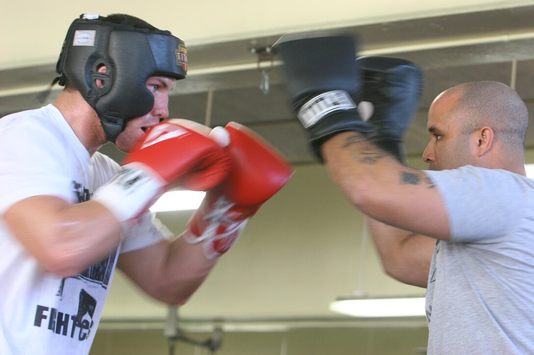 Keith Berry, professional mixed martial arts fighter practices his techniques with Anthony Day, Camp Pendleton’s boxing team coach during “Health Clinic” held at Area 33 Fitness Center Sunday.