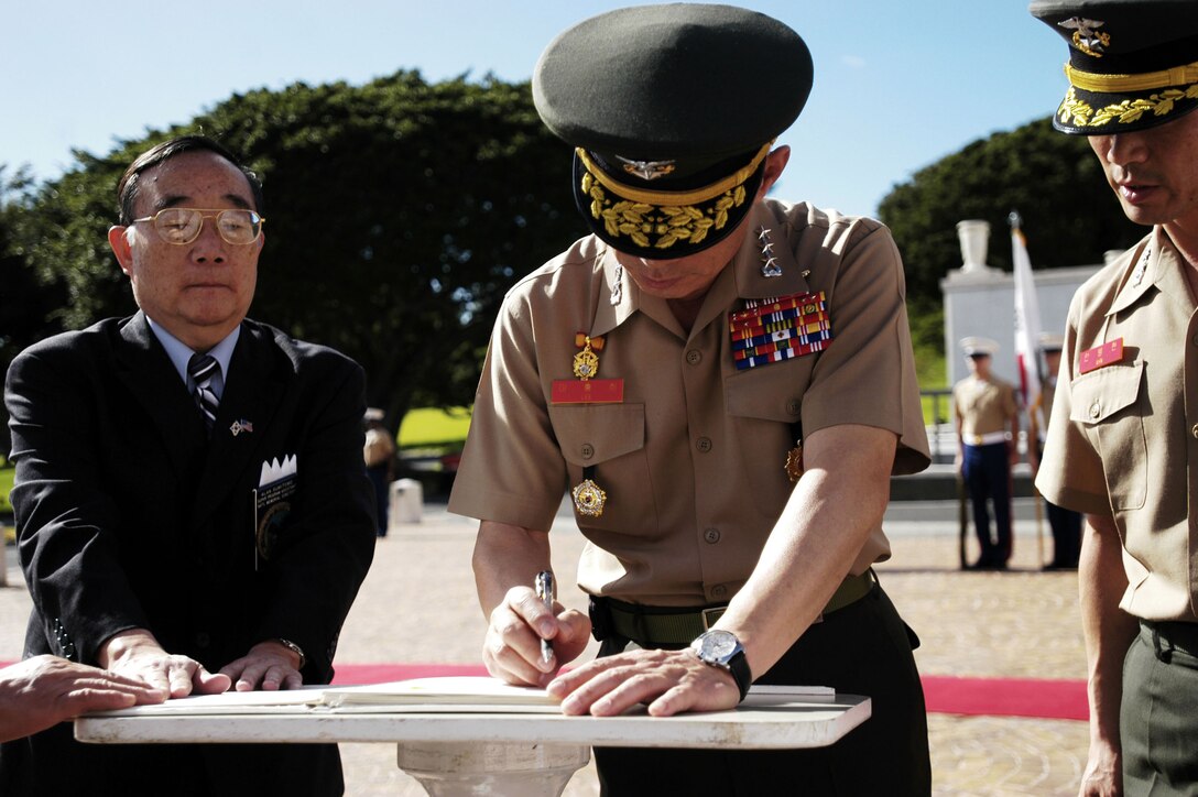 Lt. Gen. Lee Hong Hee, commandant of the Republic of Korea Marine Corps, signs an official guest book commemorating his visit to pay tribute to fallen service members who fought for his country more than 50 years agoat the National Memorial Cemetery of the Pacific (Punchbowl) here Jan. 19.