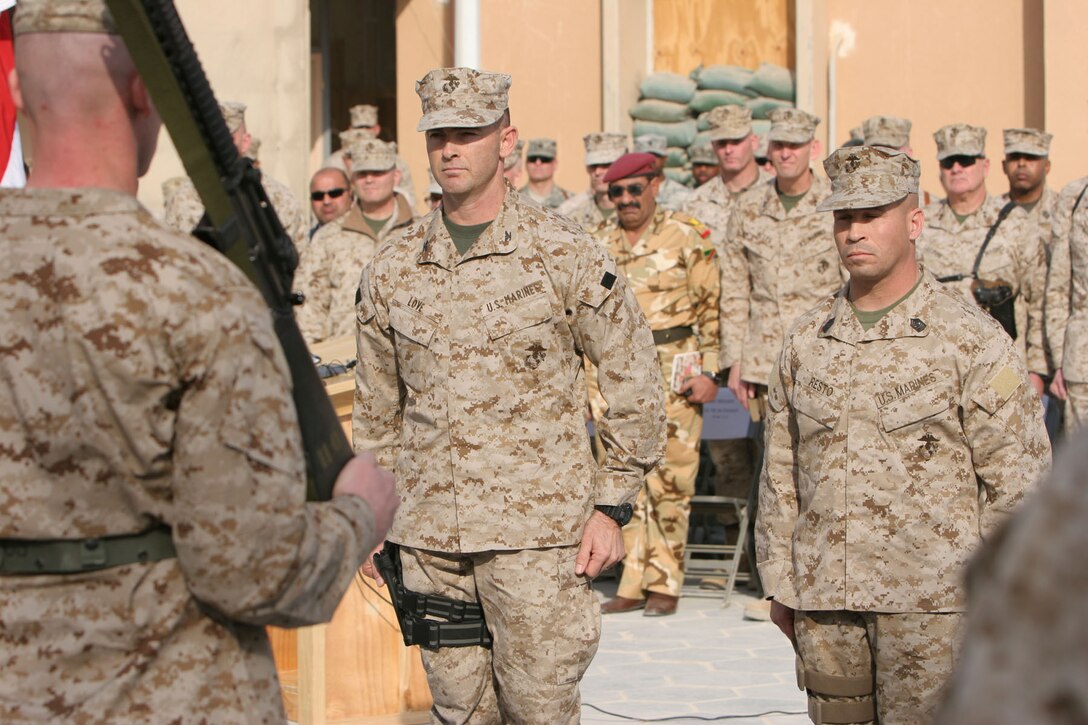 Col. John K. Love, center, commanding officer, Regimental Combat Team 8, and Sgt. Maj. Rudy Resto, regimental sergeant major, RCT-8, assume control of Coalition Forces operations in western al-Anbar province, Iraq, during a relief in place/transfer of authority ceremony Jan. 19 at Camp Ripper. Love and his Marines from RCT-8 are taking over an area covering 70,000 miles, roughly the size of South Carolina, and will be helping the Iraqis improve their security and infrastructure.