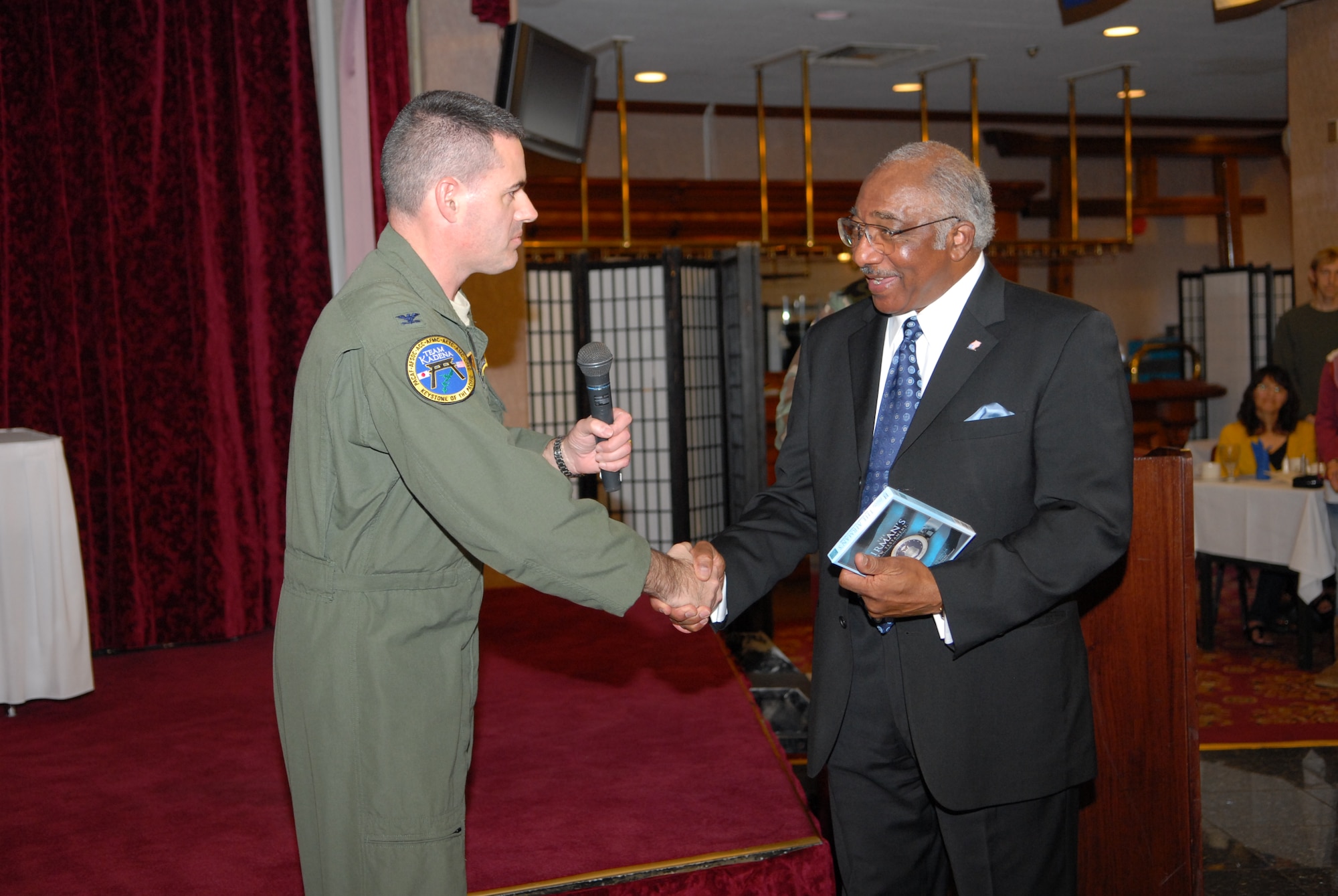 Col. Lenny Richoux, 18th Wing vice commander, thanks Col. (Ret.) Richard Toliver, a former F-15 test pilot and second generation Tuskegee Airman, for speaking at the Martin Luther King Jr. Day luncheon Jan. 16, 2009 at the Rocker NCO Club, Kadena Air Base, Japan.  (U.S. Air Force photo/Staff Sgt Angelique Perez)