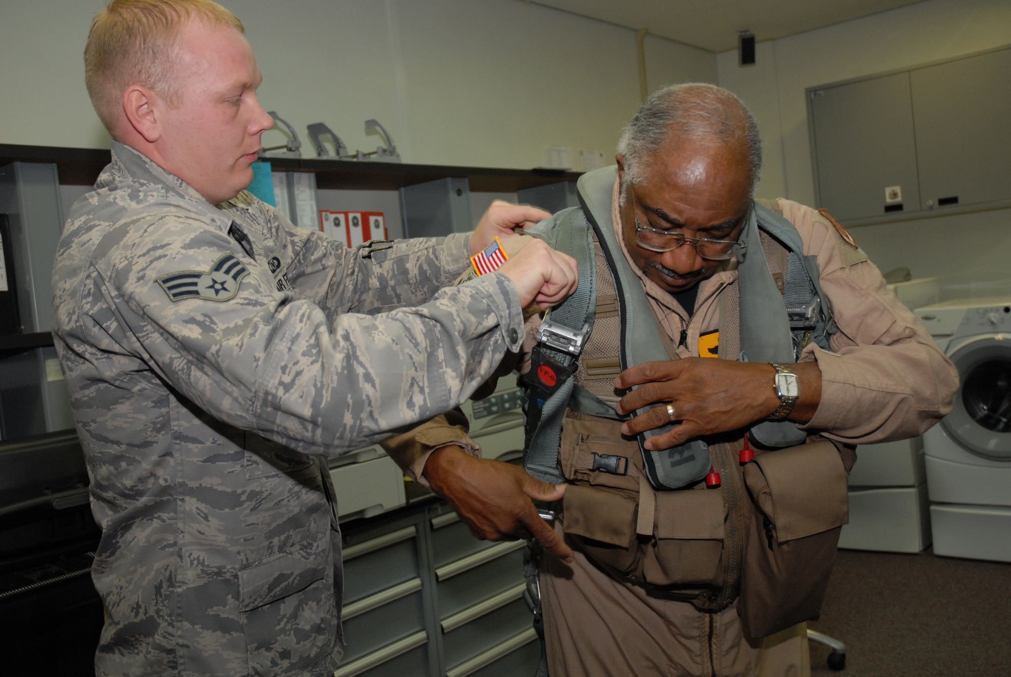 Senior Amn Richard Ebensberger, 67th Fighter Squadron aircrew life support technician, fits Col. (Ret.) Richard Toliver, a former F-15 test pilot and second generation Tuskegee Airman, with a helmet and G-suit for an incentive flight in an F-15D Eagle Jan. 15, 2009 during his visit to Kadena Air Base, Japan. Col. Toliver later spoke to more than 400 people at the base's observance of Martin Luther King Jr. Day. (U.S. Air Force photo/Staff Sgt Angelique Perez)