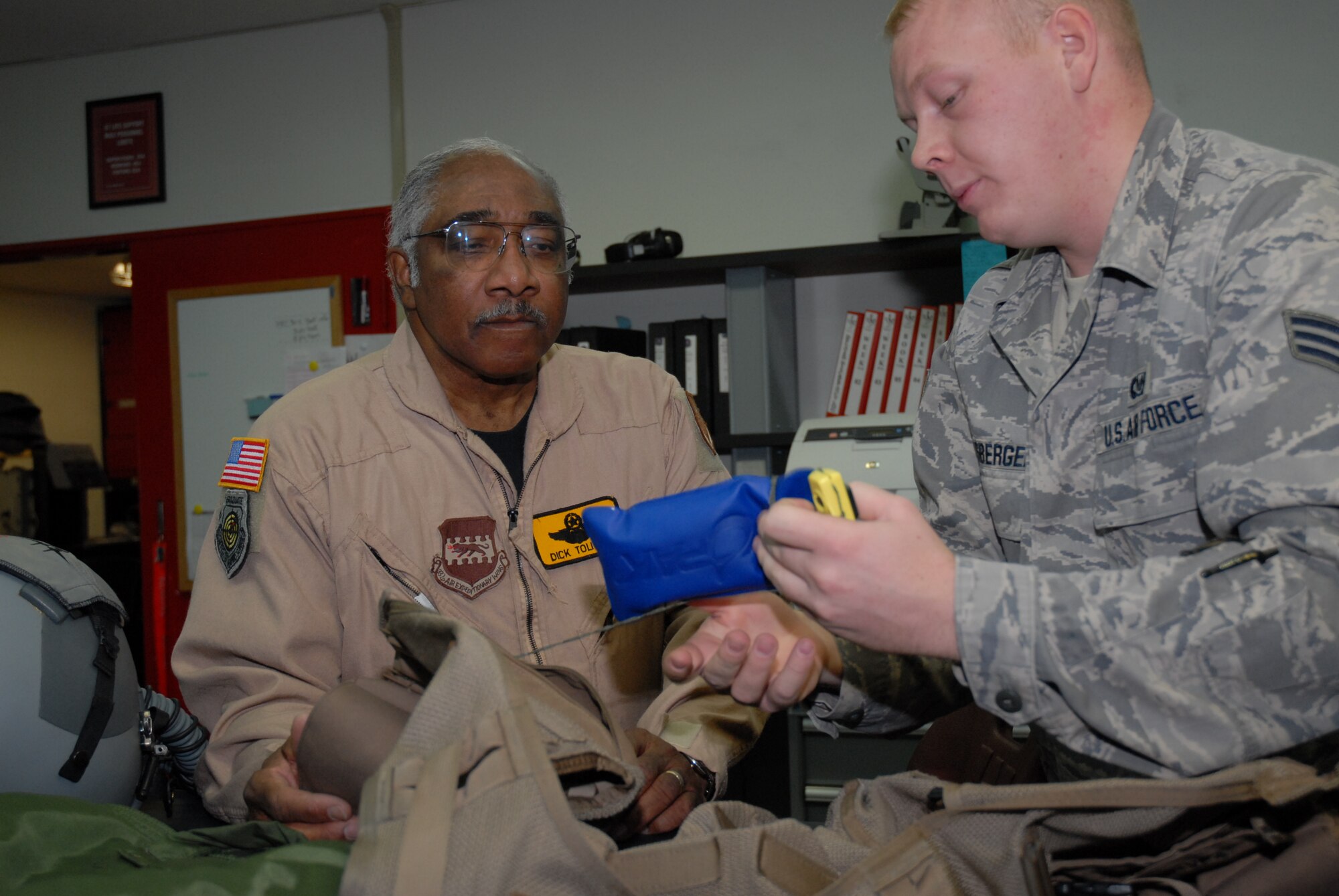 Senior Airman Richard Ebensberger, 67th Fighter Squadron aircrew life support technician, fits Col. (Ret.) Richard Toliver, a former F-15 test pilot and second generation Tuskegee Airman, with a helmet and G-suit for an incentive flight in an F-15D Eagle Jan. 15, 2009 during his visit to Kadena Air Base, Japan.  Col. Toliver later spoke to more than 400 people at the base's observance of Martin Luther King Jr. Day. (U.S. Air Force photo/Staff Sgt Angelique Perez)