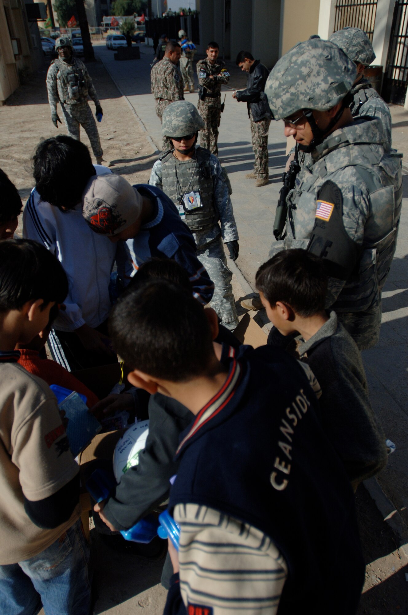 Capt. Ben Washburn, 732nd Expeditionary Security Forces Squadron Detachment 4 operations officer, hands out toys, school supplies and clothes while on foot-patrol in an apartment complex in Baghdad, Iraq, International Zone Jan. 10. The items were gathered by a group of volunteer servicemembers at Joint Base Balad, Iraq, called the Kids of Iraq. The items come from donators in the United States. Washburn currently deployed from Vogelway, Germany is a native of Colorado Springs, Colo. (U.S. Air Force photo/Tech. Sgt. Craig Lifton)