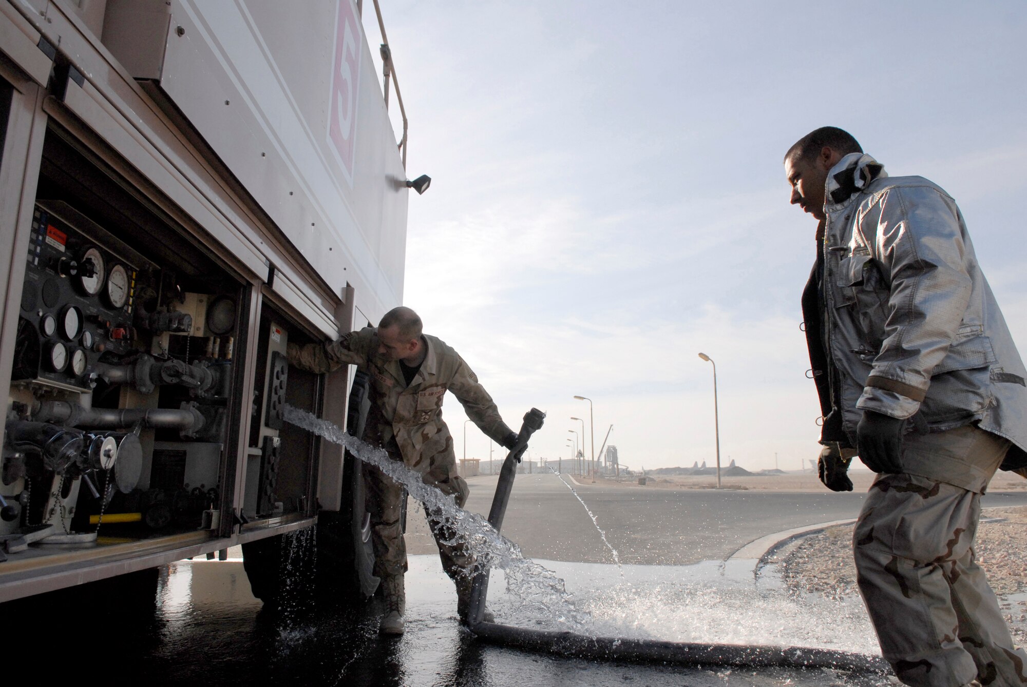Senior Airman Brian Yates and Senior Airman Daniel Smith, 379th Expeditionary Civil Engineering Squadron Flightline Station Fire Fighters, release the hose after their morning maintenance water refill, Jan. 17, 2009, at an undisclosed location in Southwest Asia.  Senior Airman Yates hails from Jackson, Ohio and is deployed from Shaw Air Force Base, S.C.  Senior Airman Smith hails from San Antonio, Texas and is deployed from Beale, Calif.  Both are deployed in support of Operation Iraqi and Enduring Freedom and Joint Task Force- Horn of Africa.  (U.S. Air Force Photo by Airman 1st Class Andrew Satran/Released)