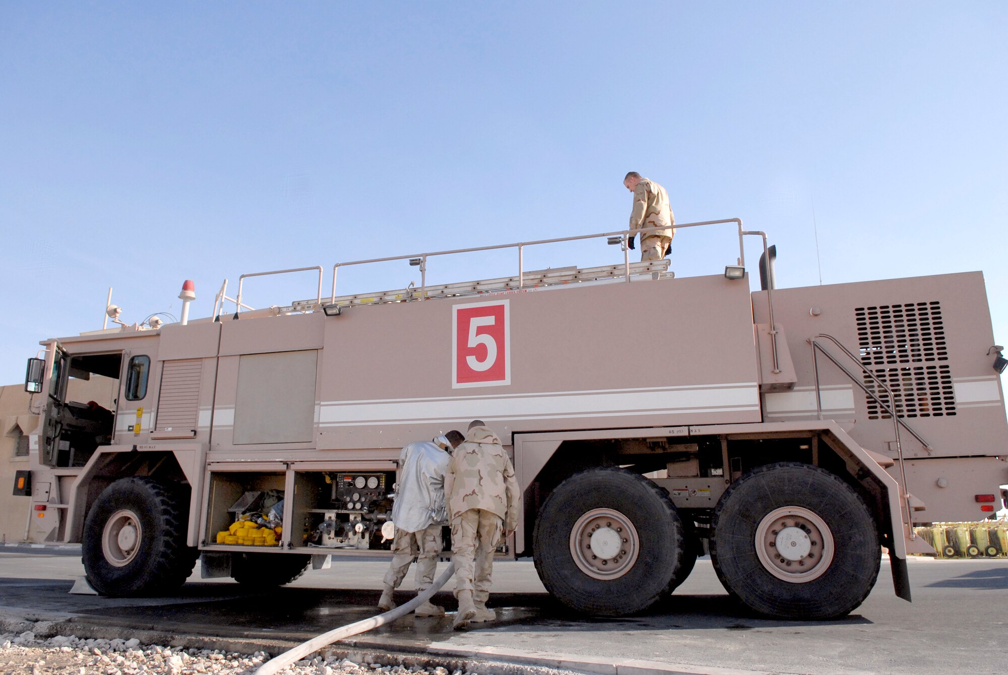 379th Expeditionary Civil Engineering Squadron (ECES) Flightline Station Fire Fighters refill their fire engine with water as a part of their morning maintenance, Jan. 17, 2009, at an undisclosed location in Southwest Asia.  379th ECES fire fighters are deployed from bases all over the world in support of Operation Iraqi and Enduring Freedom and Joint Task Force- Horn of Africa.  (U.S. Air Force Photo by Airman 1st Class Andrew Satran/Released)