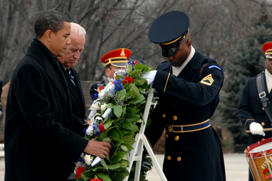 Army Sgt. 1st Class Alfred Lanier, right, a tomb sentinel assigned to the 3rd U.S. Infantry Regiment, "The Old Guard," helps President-elect Barack Obama and Vice President-elect Joe Biden place a wreath at the Tomb of the Unknowns at Arlington National Cemetery in Virginia during a ceremony on Jan. 18, 2009.