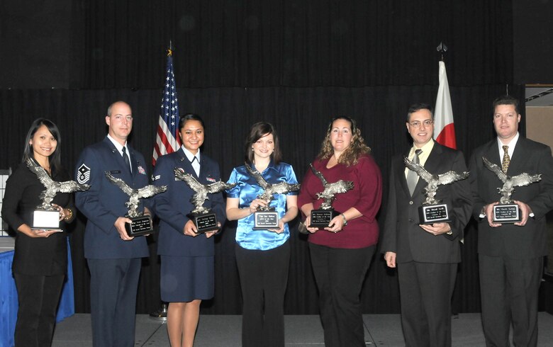 From left: Tammie Gilmore, Master Sgt. Scott Ragnone, Airman 1st Class Taliilagi Falelua, Ariel Eishen, Shannan Anthony, David Sterle, and Garth Sutton pose for photograph after winning their category at the 353rd Special Operations Group annuals awards ceremony Jan. 16.  Mrs. Gilmore and Mrs. Eishen are representing their husbands, Master Sgt. Shawn Gilmore and Tech. Sgt. Ian Eishen, who were unable to attend. Capt. Kelly Kruger, the group's Company Grade Officer of the Year was also unable to attend the ceremony. (Photo by Tech. Sgt. Aaron Cram)