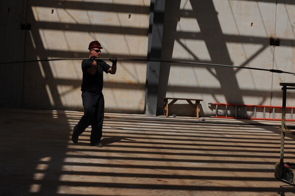 Staff Sgt. Degeo Schultz moves ceiling support rods into a tilt-up style building Jan. 13 at Northwest field, Andersen Air Force Base, Guam. The 10-year construction plan will provide 80 facilities and infrastructure supporting four units: 554th and 254th RED HORSE Squadrons, Commando Warrior, 644th Combat Communications and 554th Silver Flag building PACAF's future premier Expeditionary Combat Skills Training Campus. Sgt. Schultz is assigned to the 554th Red Horse Squadron at Andersen.
(U.S. Air Force photo/ Master Sgt. Kevin J. Gruenwald) released
