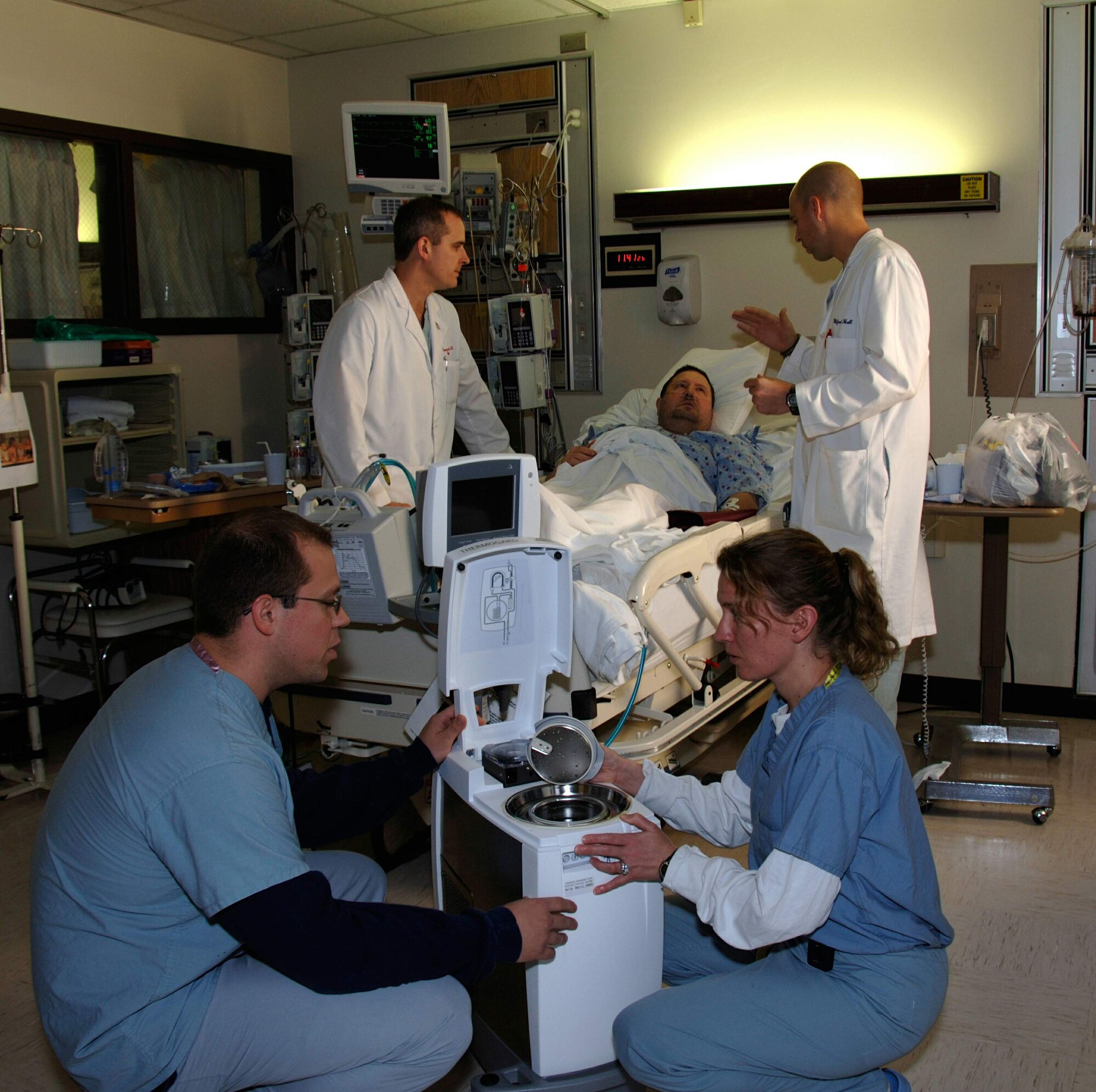 Capt. (Dr.) Jason Higey (left front) and Maj. (Dr.) Karin Hawkins (right front) prepare to show a patient a therapeutic hypothermia machine as Maj. (Dr.) Benjamin Romick (back left) and Dr. Andrew Muck (back right) explain how the machine was used to treat him at Wilford Hall Medical Center at Lackland Air Force Base, Texas.  (U.S. Air Force photo/Master Sgt. Kimberly A. Yearyean-Siers)
