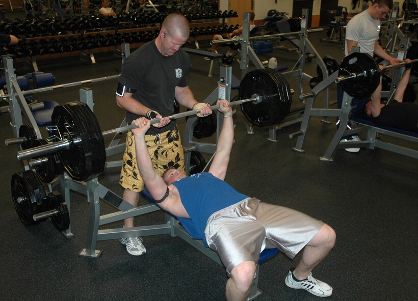 MINOT AIR FORCE BASE, N.D. -- Airman 1st Class Brady Fender, 5th Aircraft Maintenance Squadron weapons armament specialist, performs a bench press exercise with the help of a spotter at the McAdoo Sports and Fitness Center here Jan. 15. Airman Fender plans to compete in the next power ladder competition at the fitness center, which occur the last Wednesday of every month. (U.S. Air Force photo by Senior Airman Wesley Wright)