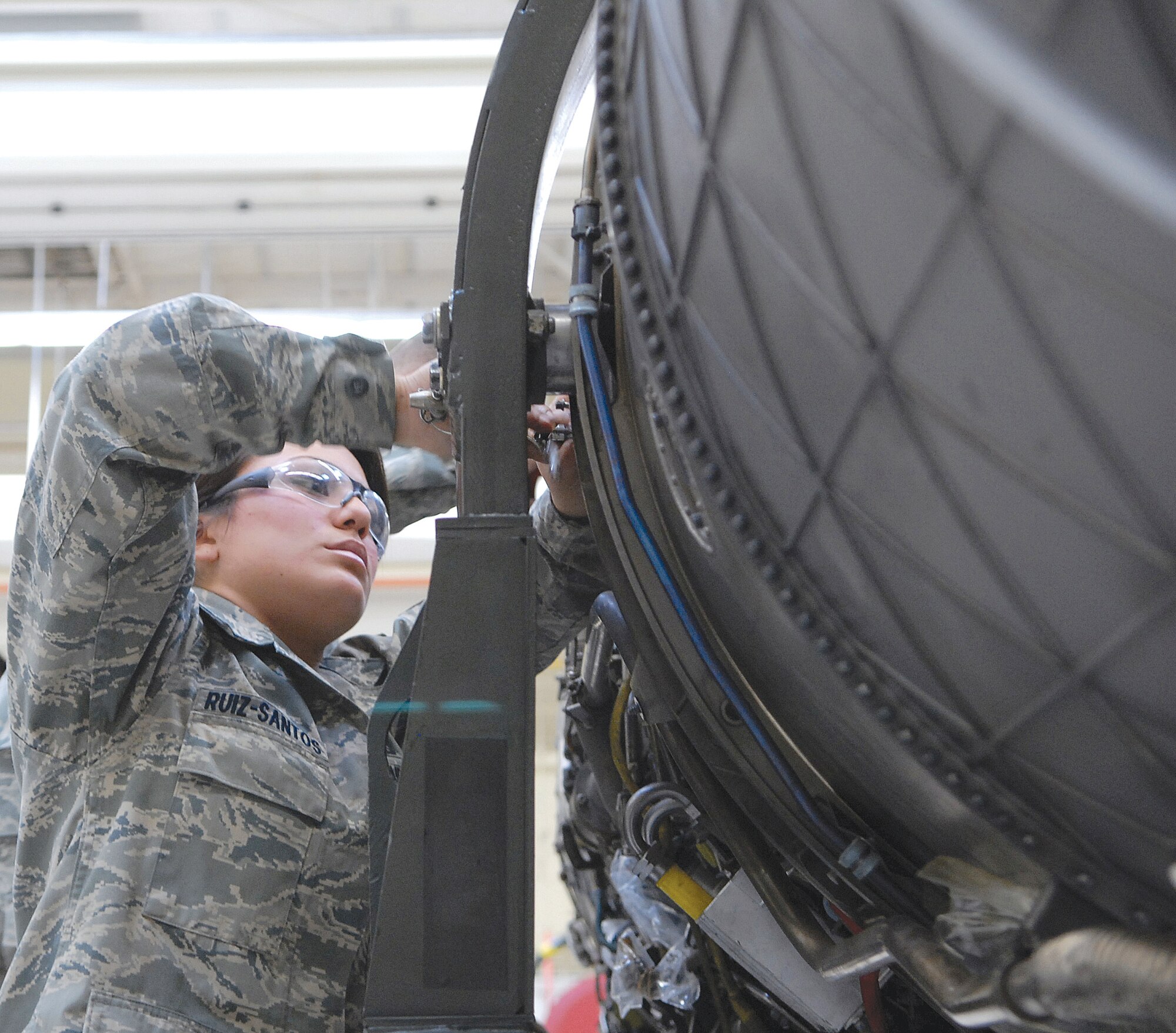 Airman 1st Class Jacqueline Ruiz-Santos, 56th Component Maintenance Squadron aerospace propulsion specialist, tightens coke bottle mounts on a jet engine prior to an engine transfer in the jet engine intermediate maintenance shop January 12. In JEIM the engine comes in from the line to be fixed. (U.S. Air Force photo by SSgt Phillip Butterfield) 