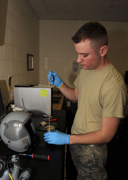 DYESS AIR FORCE BASE, Texas -- Airman 1st Class Christopher Burton, from the 7th Operation Support Squadron, prepares adhesive to apply a visor buffer to a pilot's helmet here, Jan. 15. A visor buffer is used to reduce the amount of scratches on the visor of the helmet.(U.S. Air Force photo by Senior Airman Felicia Juenke)