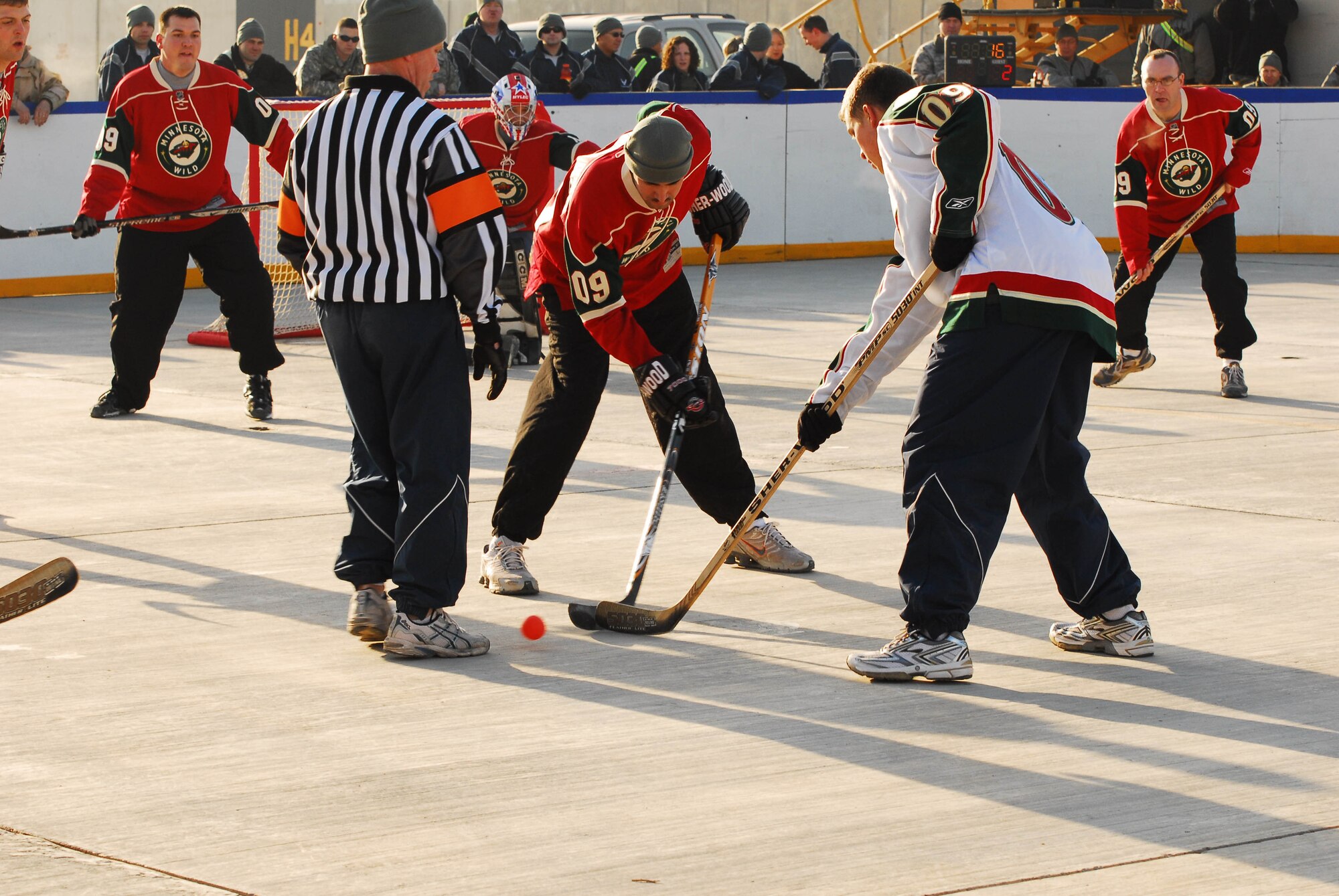 A Minnesota National Guardsman from the 148th Fighter Wing and Sgt. Jeff Fischbach (in Red), from Inver Grove Heights, MN, of the 834th Aviation Support Battalion face off at a game of floor hockey on Joint Base Balad, Iraq on Jan. 17.