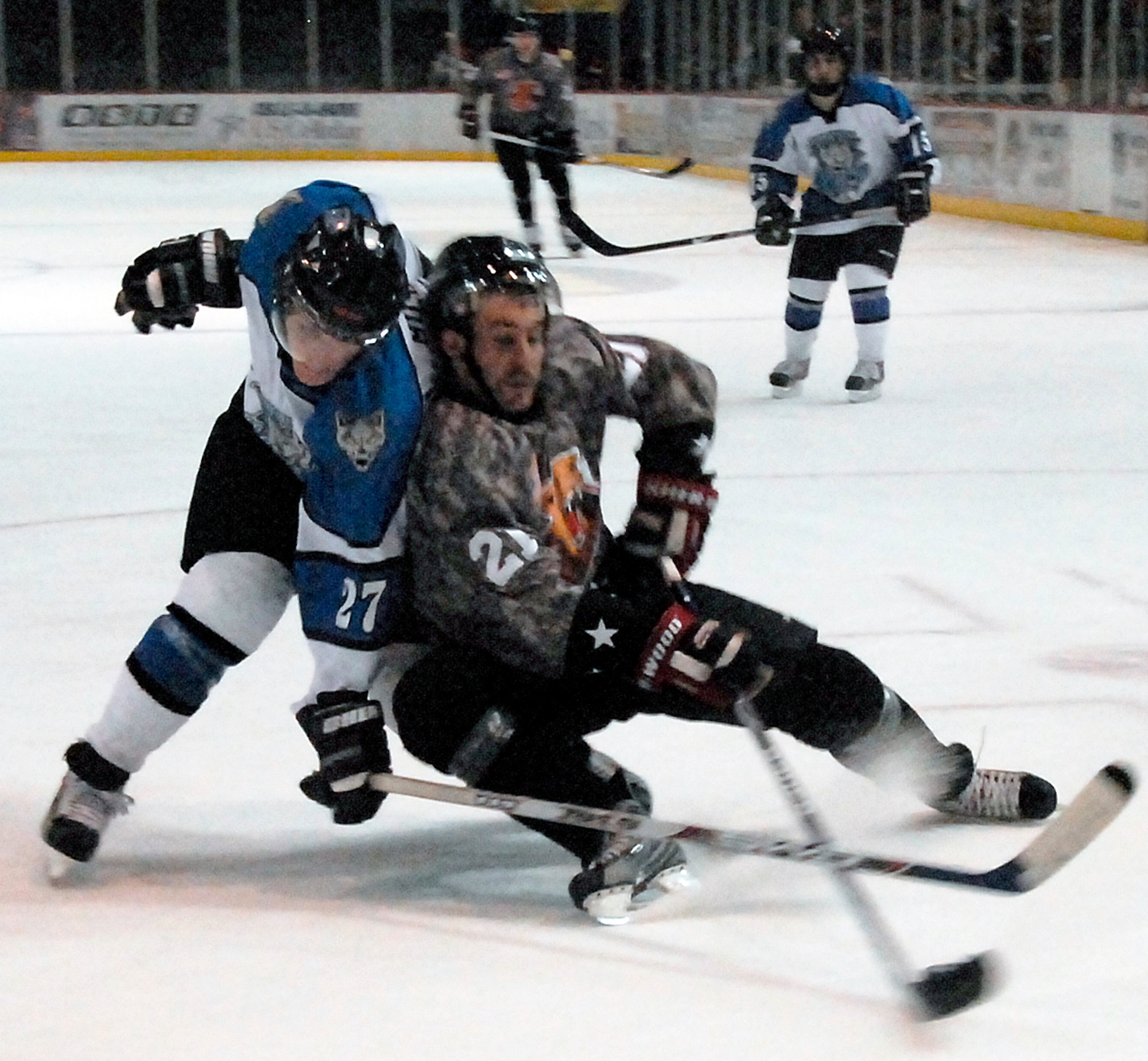 Wichita Falls Wildcats forward Brett Hartung, right, battles Billy Miller, a defenseman for the Wenatchee Wild, for the puck Jan. 17 during the Wildcats annual Military Appreciation Night. The Wildcats wore camouflaged jerseys in honor of the men and women in the nation's armed forces. The Wildcats won 4-3. (U.S. Air Force photo/Mike Litteken)