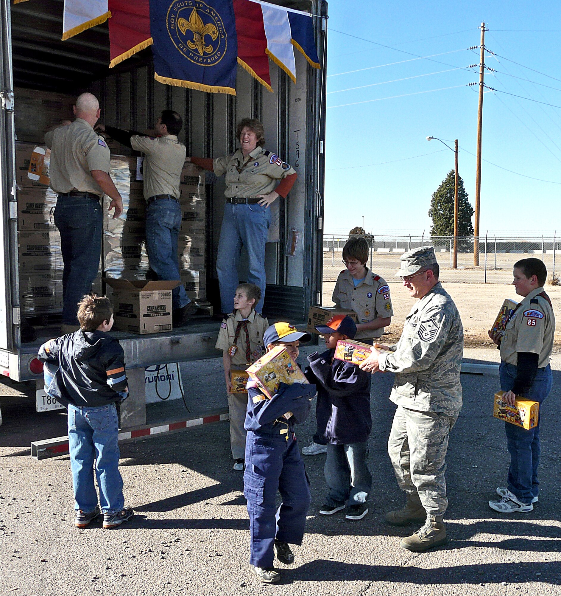 KIRTLAND AIR FORCE BASE, New Mexico -- Scouts and first sergeants unload more than 32,000 pounds of popcorn the scouts collected for base military members. The scouts are from Boy Scout Troop 85 and Cub Scout Pack 85 and they meet on base. The popcorn has been distributed to military members throughout the base. U.S. Air Force photo by Master Sgt. Robert Scott