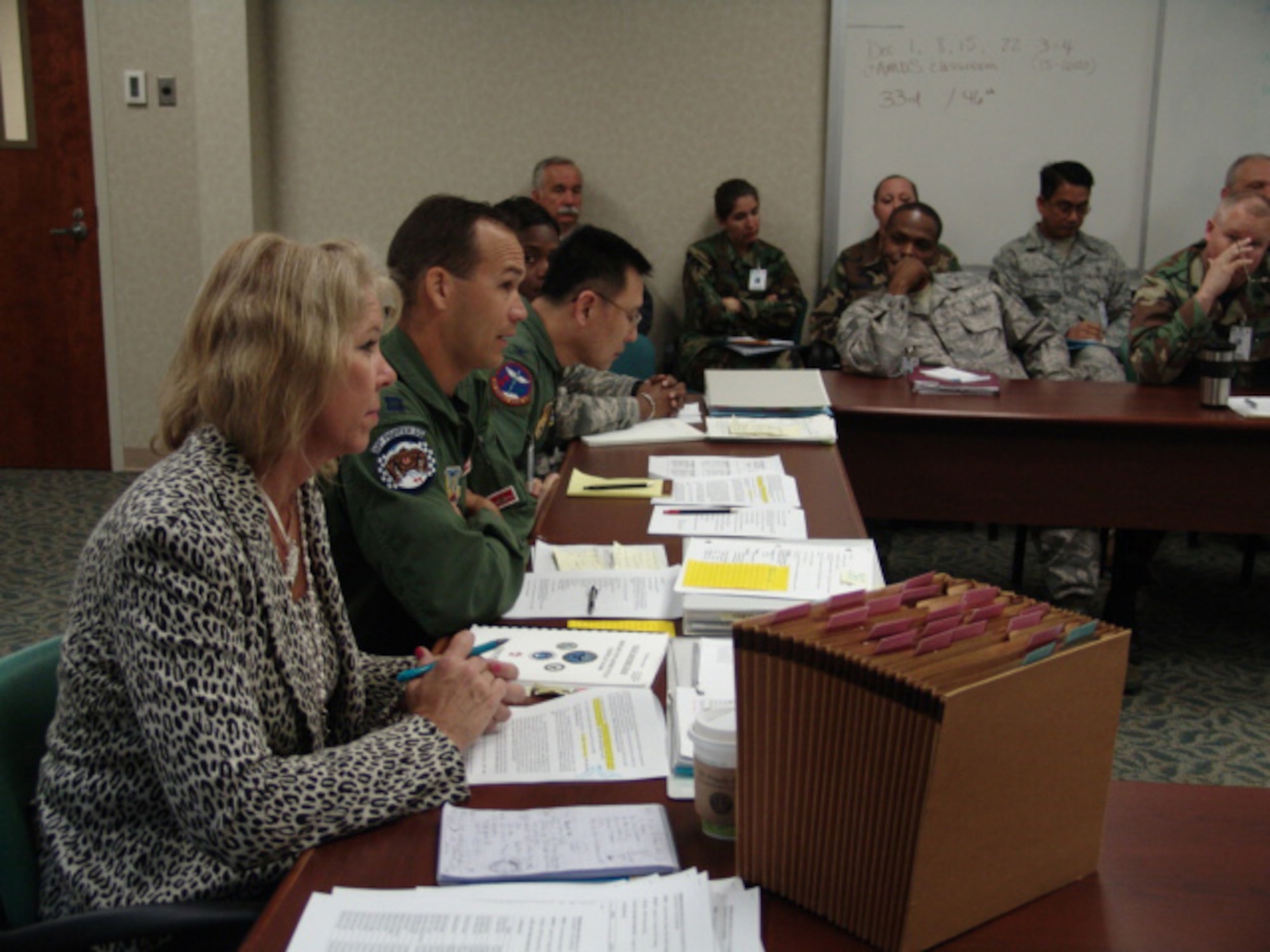 Flight surgeon Capt.  Frederick Grois, alternate Public Health Emergency Officer, briefs exercise evaluators while Public Health Specialist Karla Parrish looks on.  A Disease Containment Exercise is scheduled for the week of Feb. 2. (USAF photo/Lois Walsh)