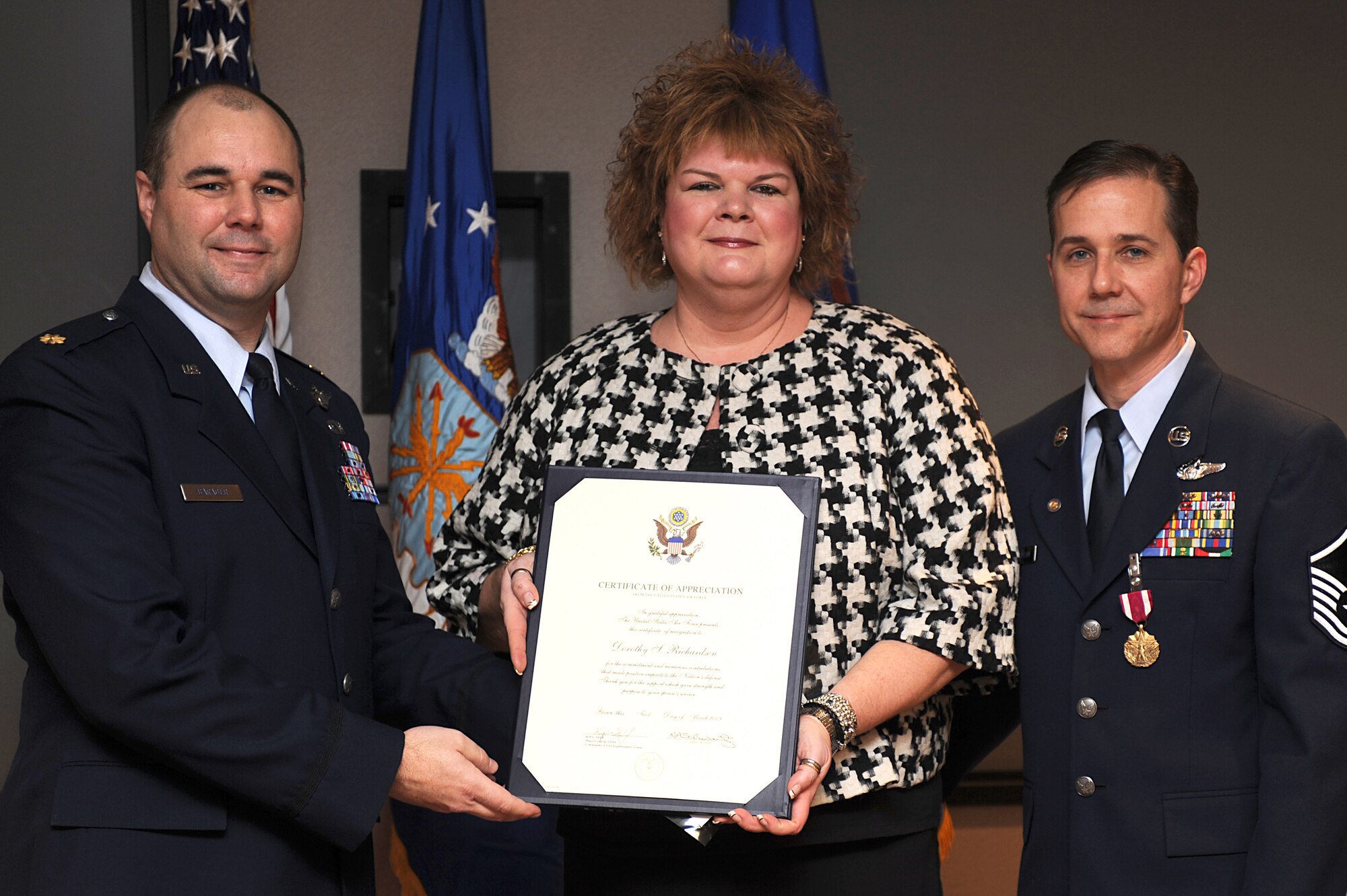 Maj. Robert Barager, Expeditionary Operations School, presents a certificate of appreciation to Dorothy, wife of Master Sgt. Peter Richardson, during Sergeant Richardson's retirement ceremony in the U.S. Air Force Expeditionary Center on Fort Dix, N.J., Jan. 9, 2009.  Sergeant Richardson was a command tactician for the Combat Aircrew Tactics Studies Course.  He was then selected to fulfill the position of Course Director for the CATS Course in his last years at the Expeditionary Center. (U.S. Air Force Photo/Staff Sgt. Nathan Bevier)