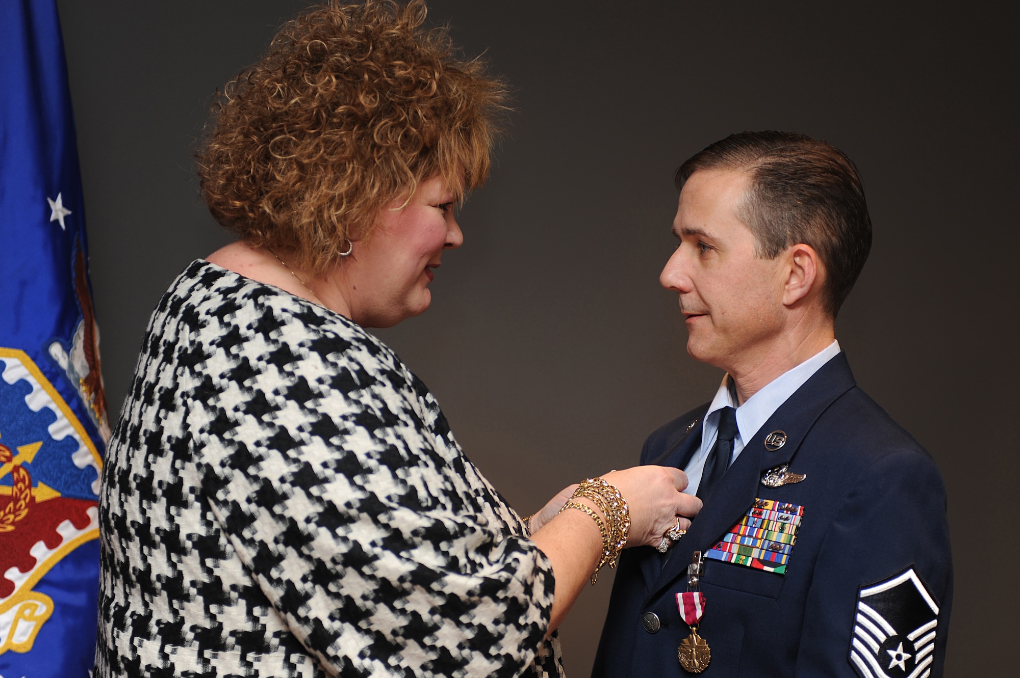 Dorothy Richardson, spouse of Master Sgt. Peter Richardson, pins a retirement pin on her husband during his retirement ceremony in the U.S. Air Force Expeditionary Center on Fort Dix, N.J., Jan. 9, 2009.  Sergeant Richardson was a command tactician for the Combat Aircrew Tactics Studies Course.  He was then selected to fulfill the position of course director for the CATS Course in his last years at the Expeditionary Center. (U.S. Air Force Photo/Staff Sgt. Nathan Bevier)