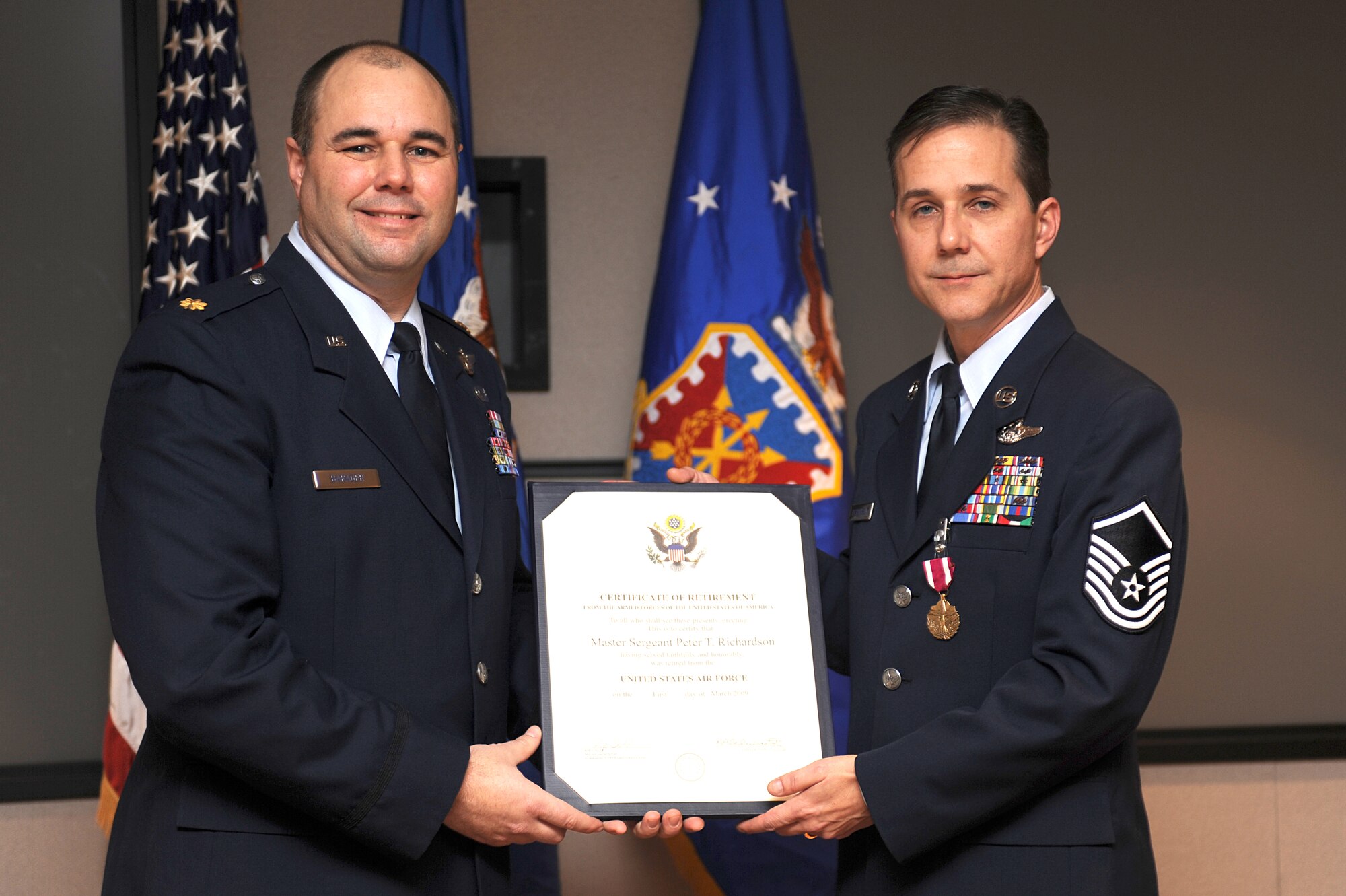 Maj. Robert Barager, Expeditionary Operations School, presents a retirement certificate to Master Sgt. Peter Richardson during his retirement ceremony in the U.S. Air Force Expeditionary Center on Fort Dix, N.J., Jan. 9, 2009.  Sergeant Richardson was a command tactician for the Combat Aircrew Tactics Studies Course.  He was then selected to fulfill the position of course director for the CATS Course in his last years at the Expeditionary Center. (U.S. Air Force Photo/Staff Sgt. Nathan Bevier)