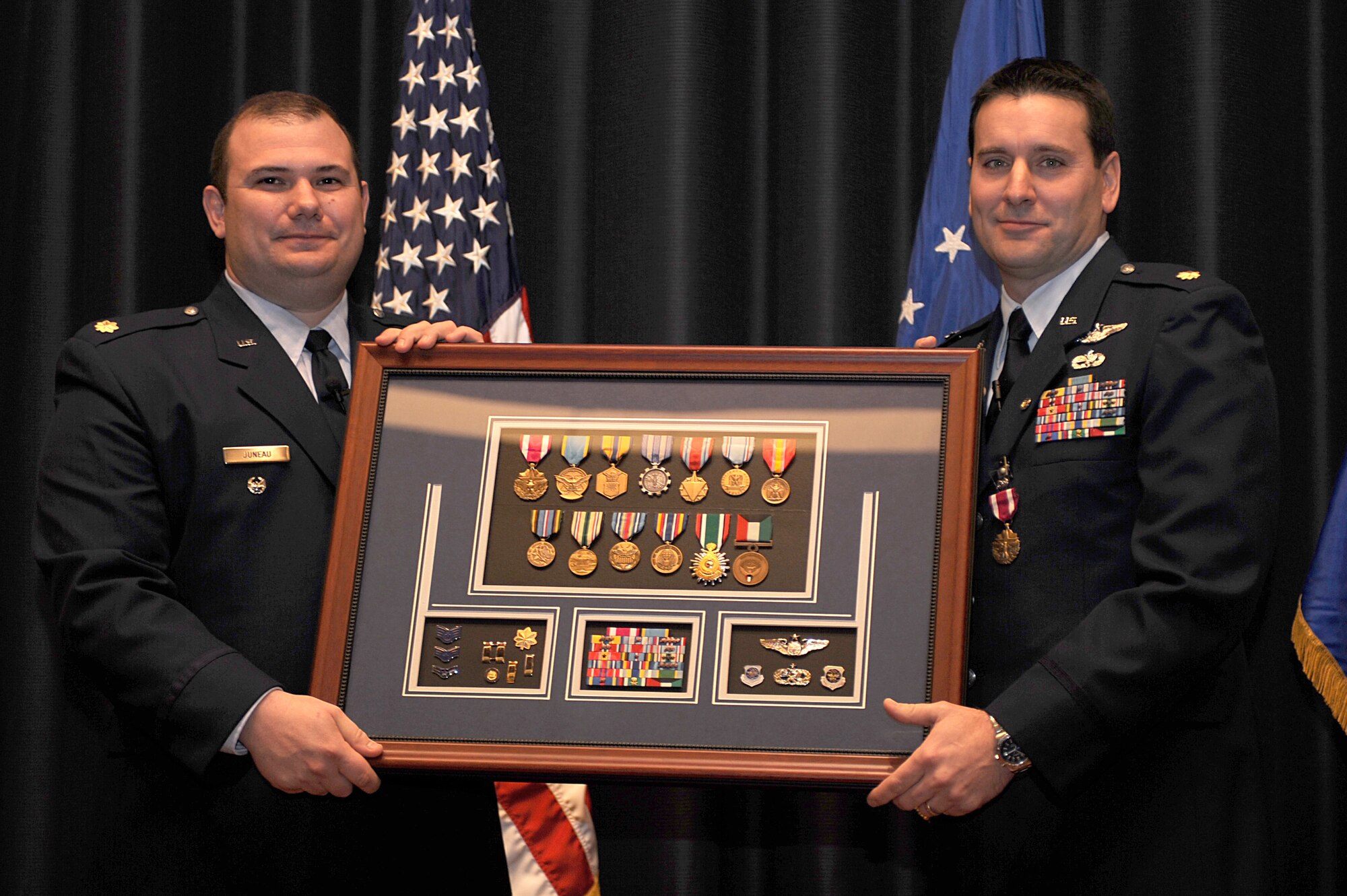 Maj. Craig Juneau, from Scott Air Force Base, Ill., presents a shadow box to Maj. John M. Yerger during his retirement ceremony at Fort Dix, N.J., Jan. 9, 2009.  Major Yerger was the assistant chief, logistics and resources for the Expeditionary Operations School at the U.S. Air Force Expeditionary Center.  Prior to this position, Major Yerger served for four years in the Air Mobility Battlelab as a project manager and the chief of finance and program support.  Major Yerger's retirement is effective on March 1.  (U.S. Air Force Photo/Staff Sgt. Nathan Bevier)