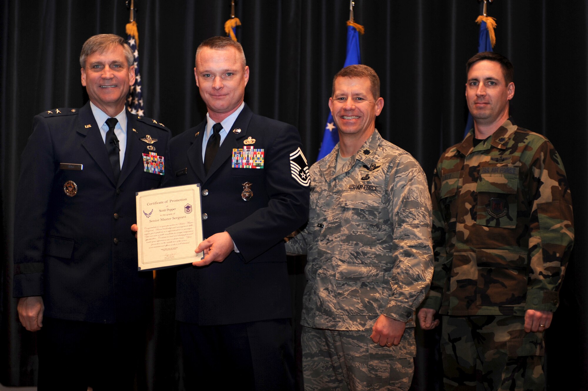 Maj. Gen. Kip Self, U.S. Air Force Expeditionary Center commander, presents Senior Master Sgt. Scott Pepper, 421st Combat Training Squadron superintendent, with a certificate of promotion during the Expeditionary Center's promotion ceremony Jan. 8, 2009, on Fort Dix, N.J.  Also pictured are Lt. Col. Mitchell Monroe, 421st CTS commander, and Lt. Col. Matthew Lacy, 421st CTS director of operations, who helped tack on Seergeant Pepper's stripes.  Sergeant Pepper's effective date of promotion was Jan. 1.  (U.S. Air Force Photo/Staff Sgt. Nathan Bevier)